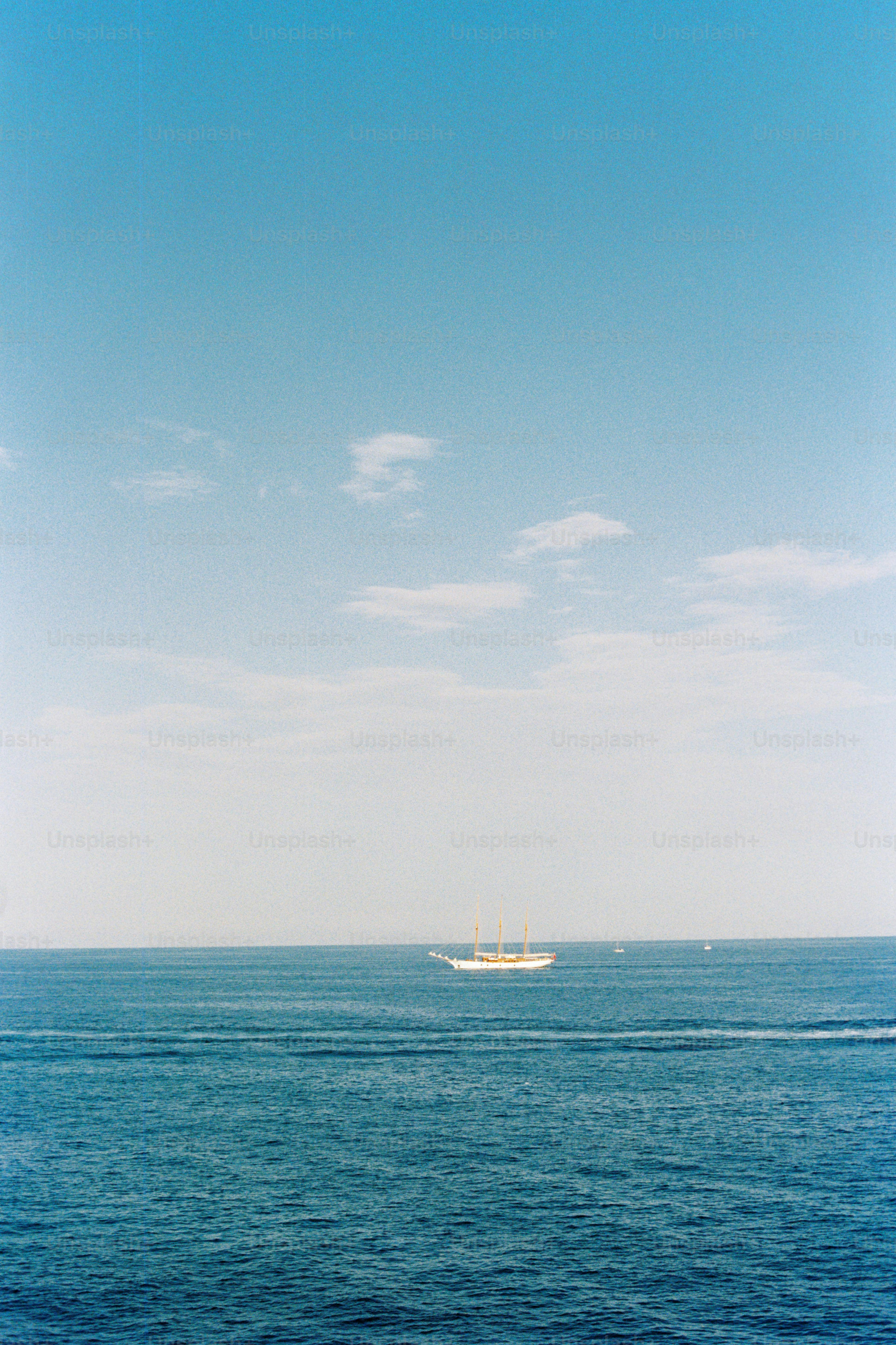 A sailing ship glides across the open ocean.