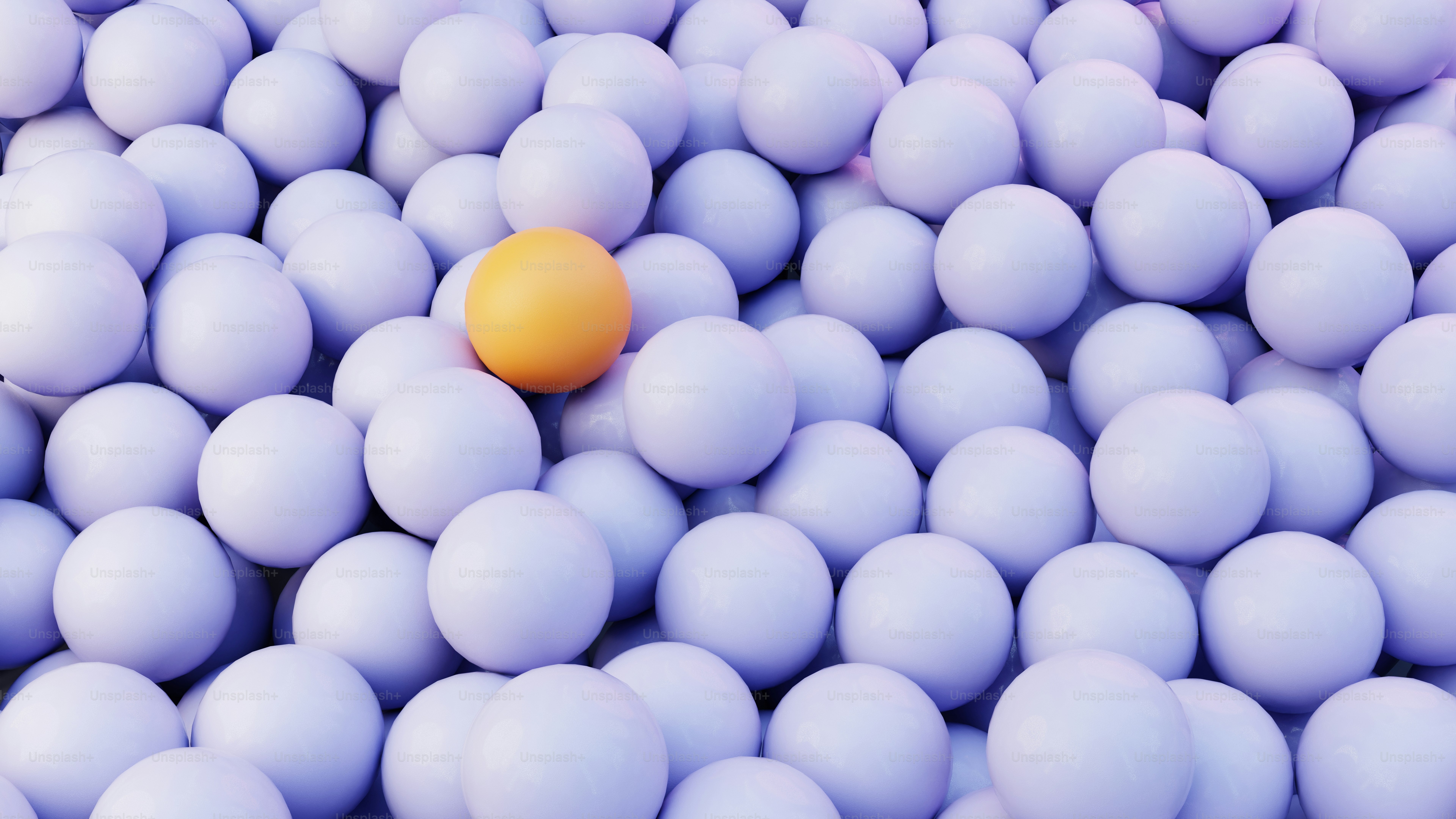 Uma esfera laranja entre muitas brancas.