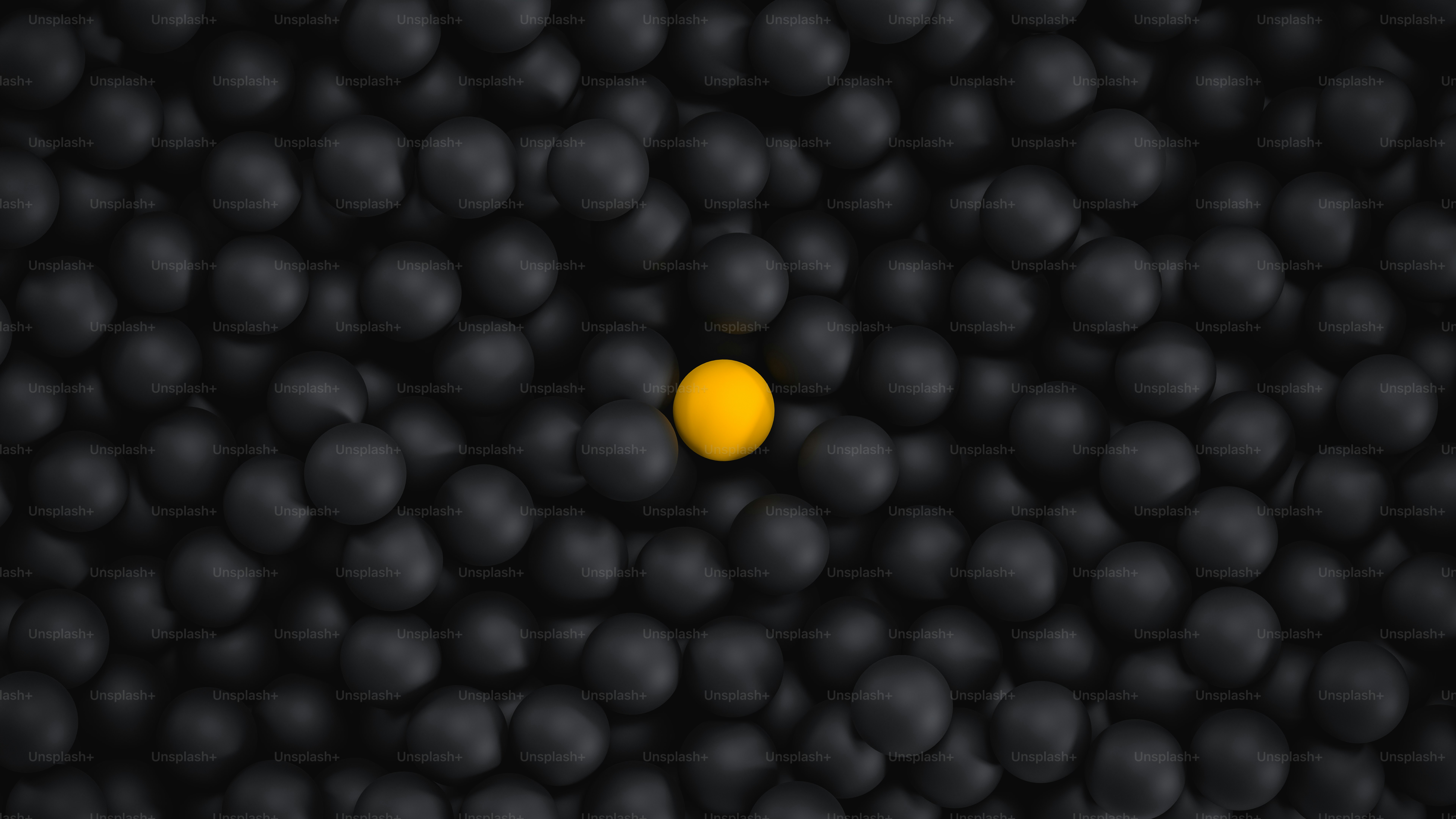 A yellow sphere stands out among black spheres.