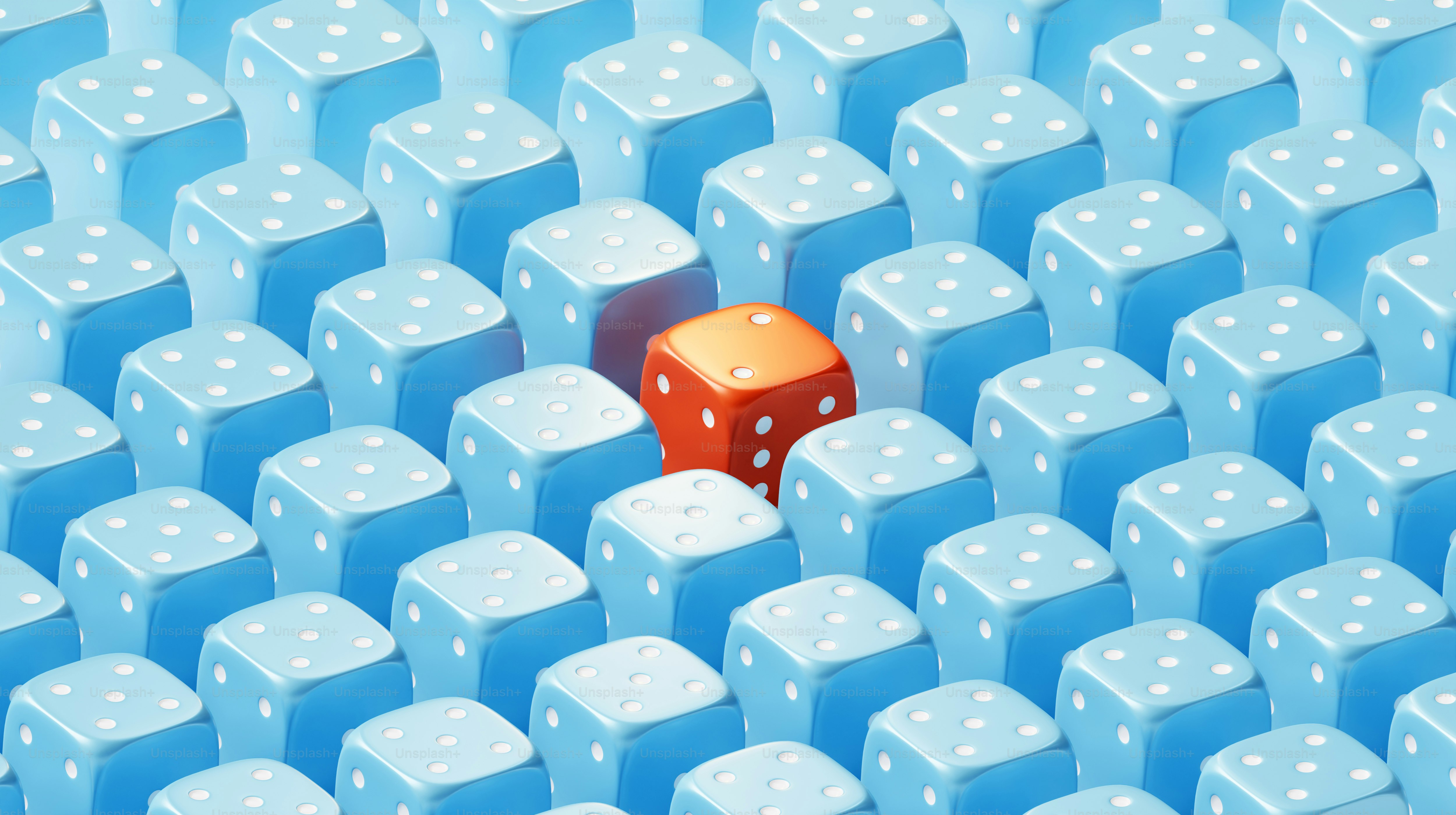 One red die stands out amongst many blue ones.