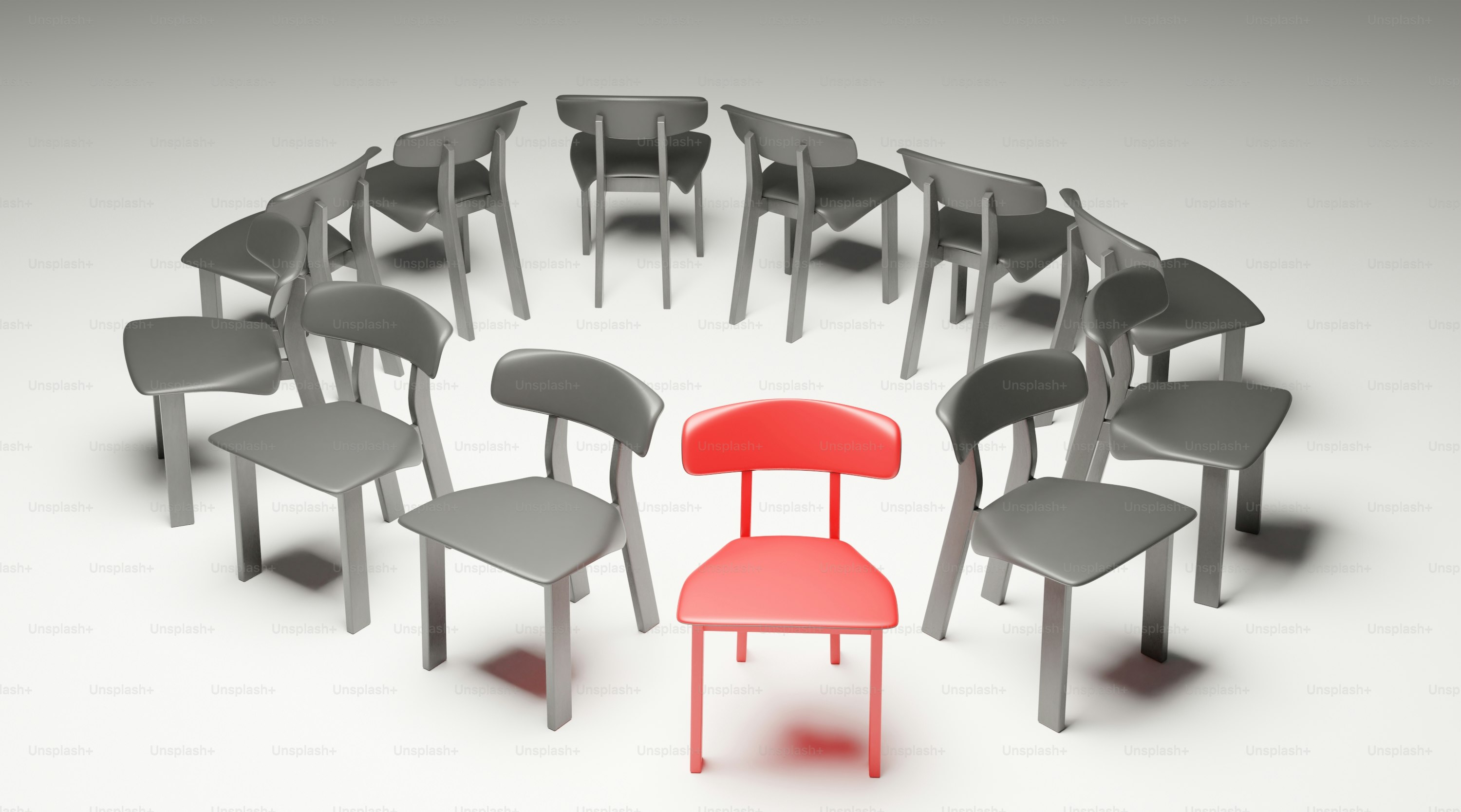 Une chaise rouge est entourée d’un cercle de chaises grises.