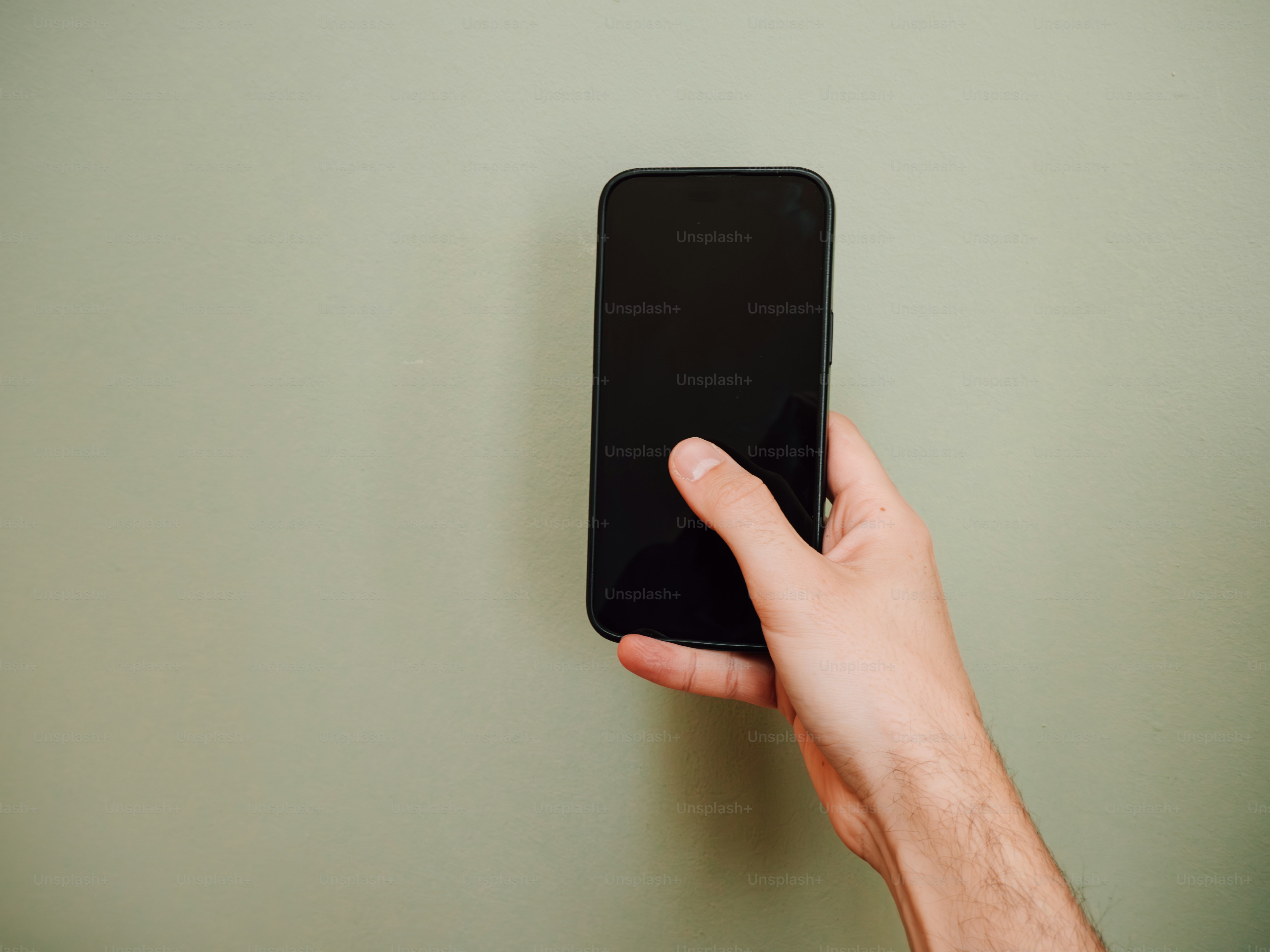 Hand holding a smartphone with a blank screen.