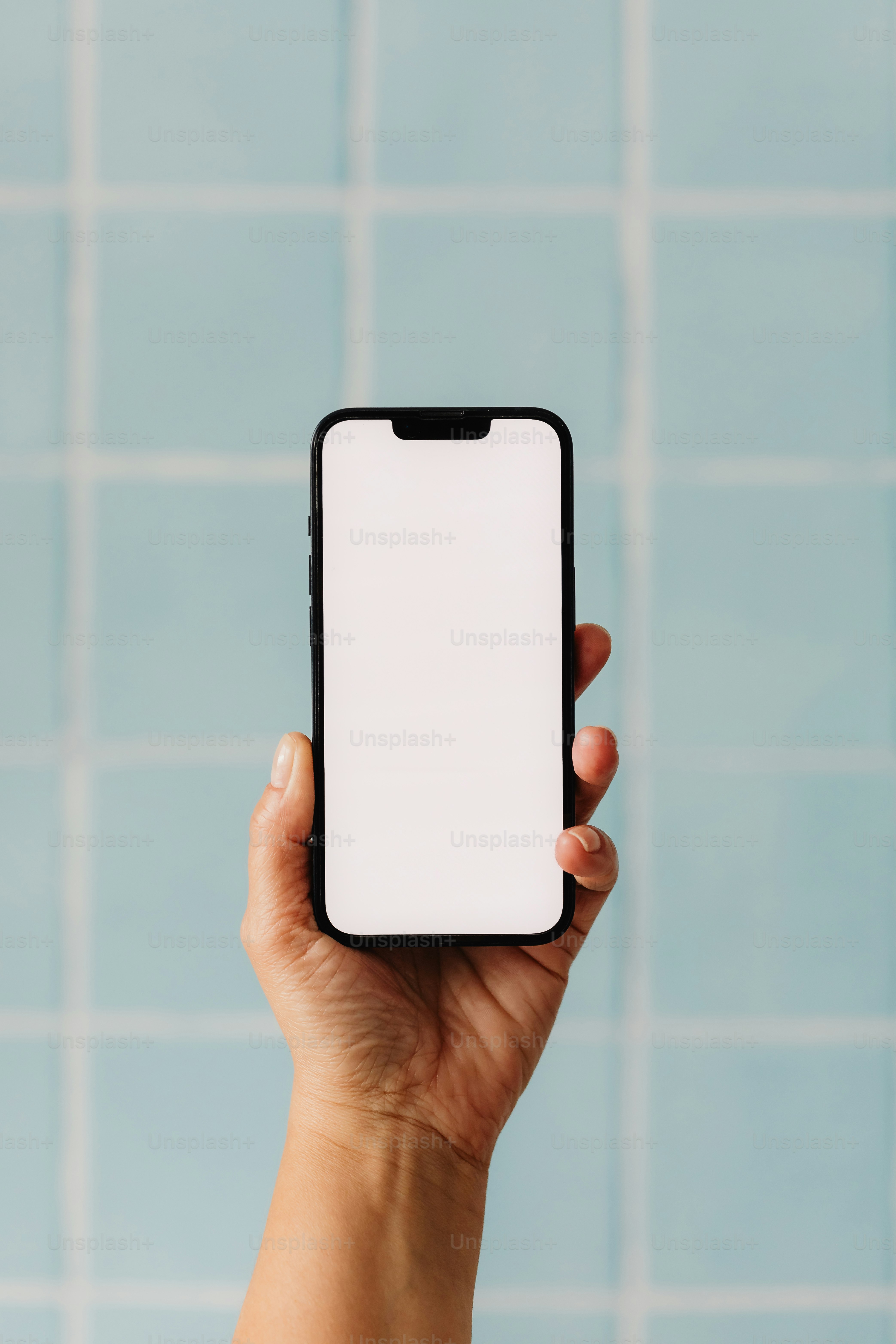 Una mano tiene lo schermo di uno smartphone vuoto.