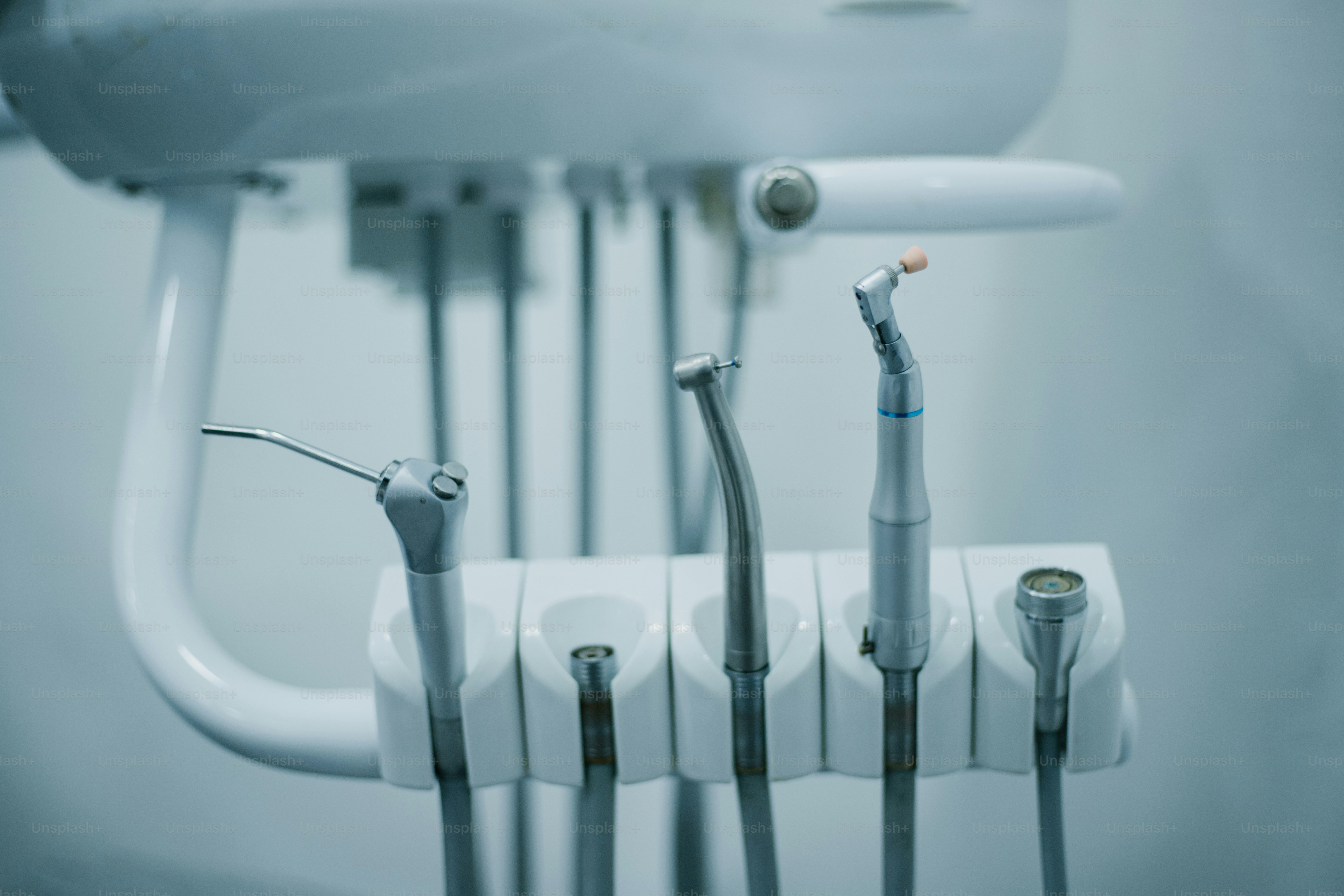 Dental instruments rest on a white holder. photo – Dental Image on Unsplash