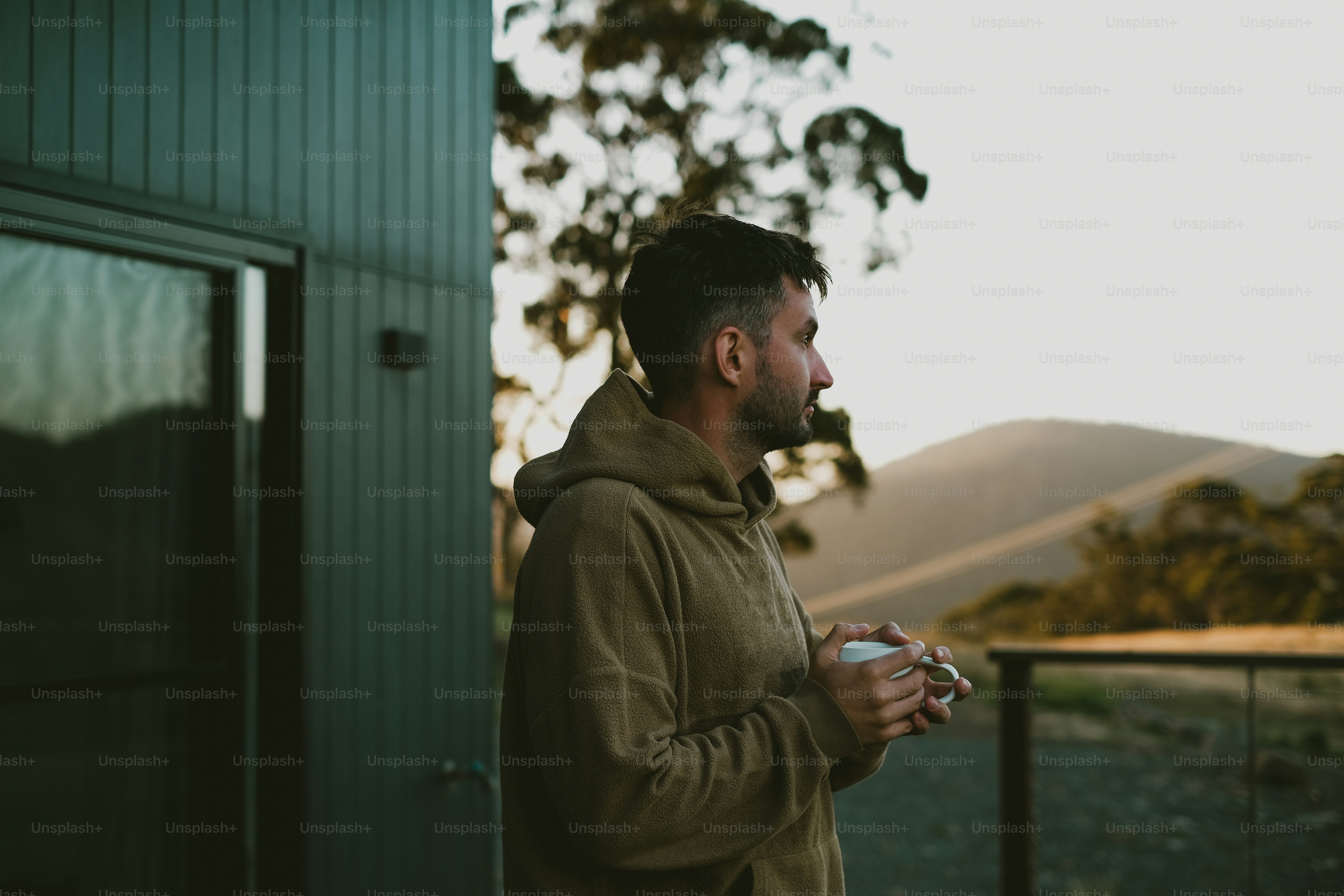 Man enjoys coffee while looking at the landscape.
