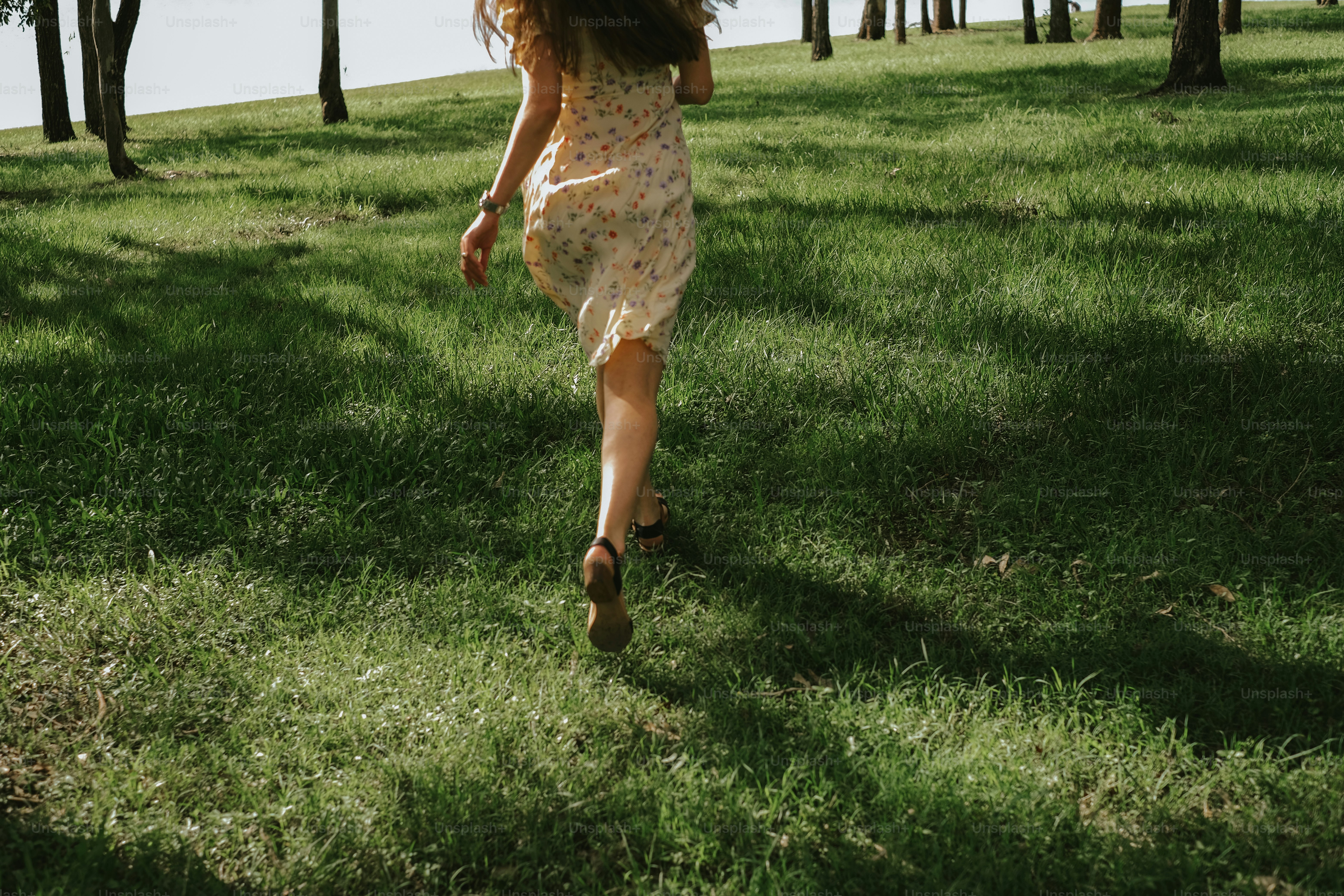 A woman runs through a green meadow.