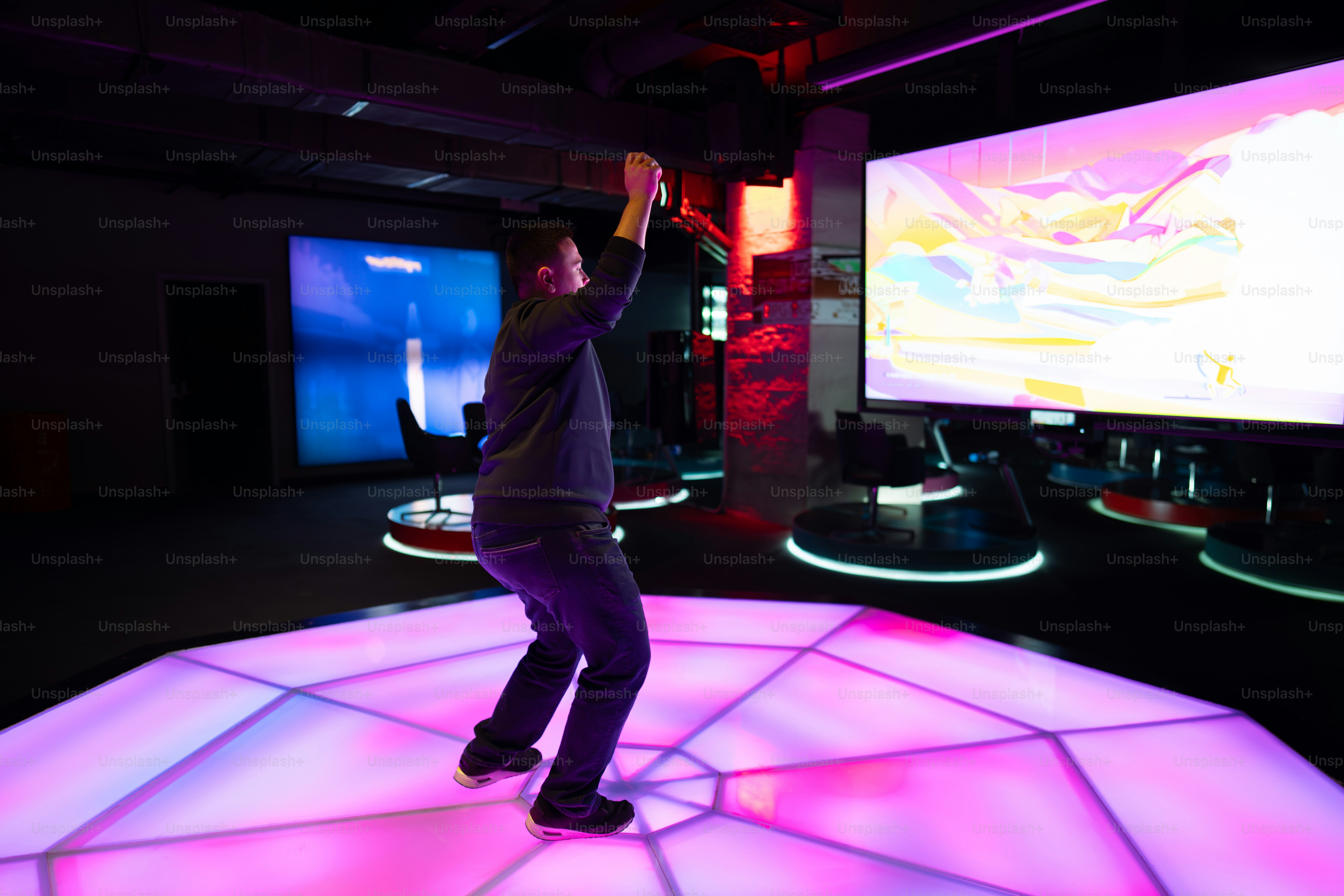 A person dances on a lighted dance floor.