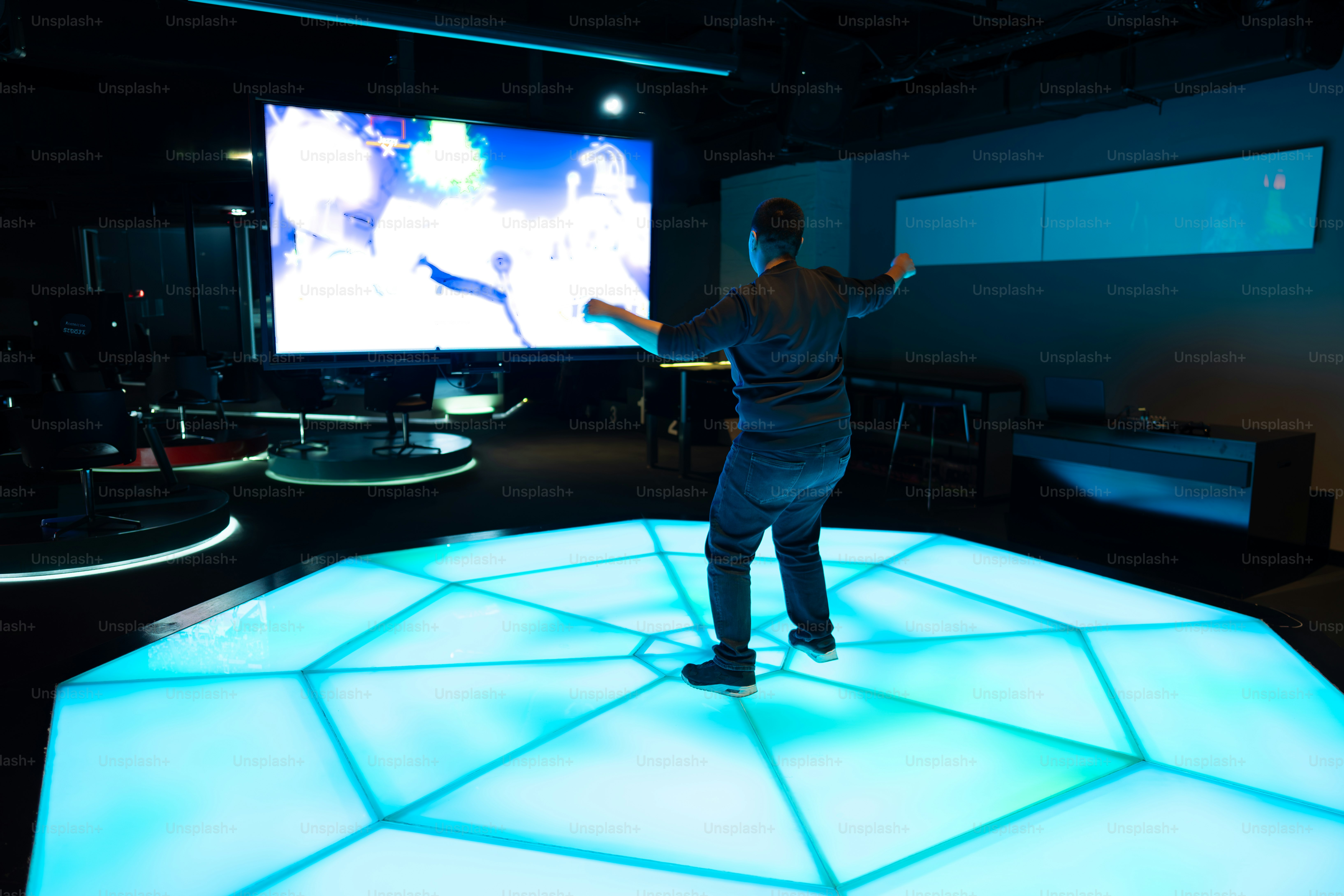 Man dances on an interactive illuminated dance floor.