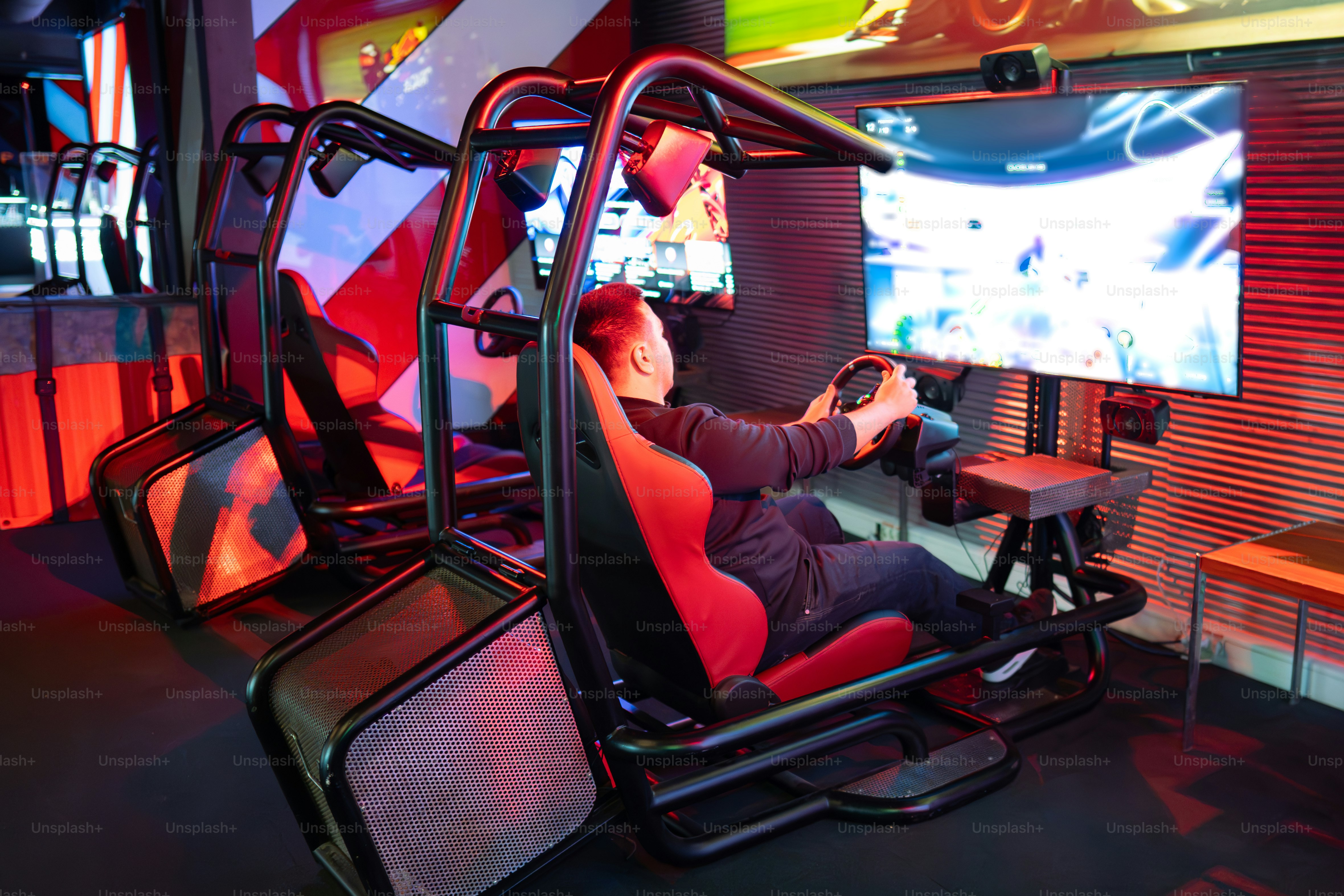 Man plays a racing game on a simulator.