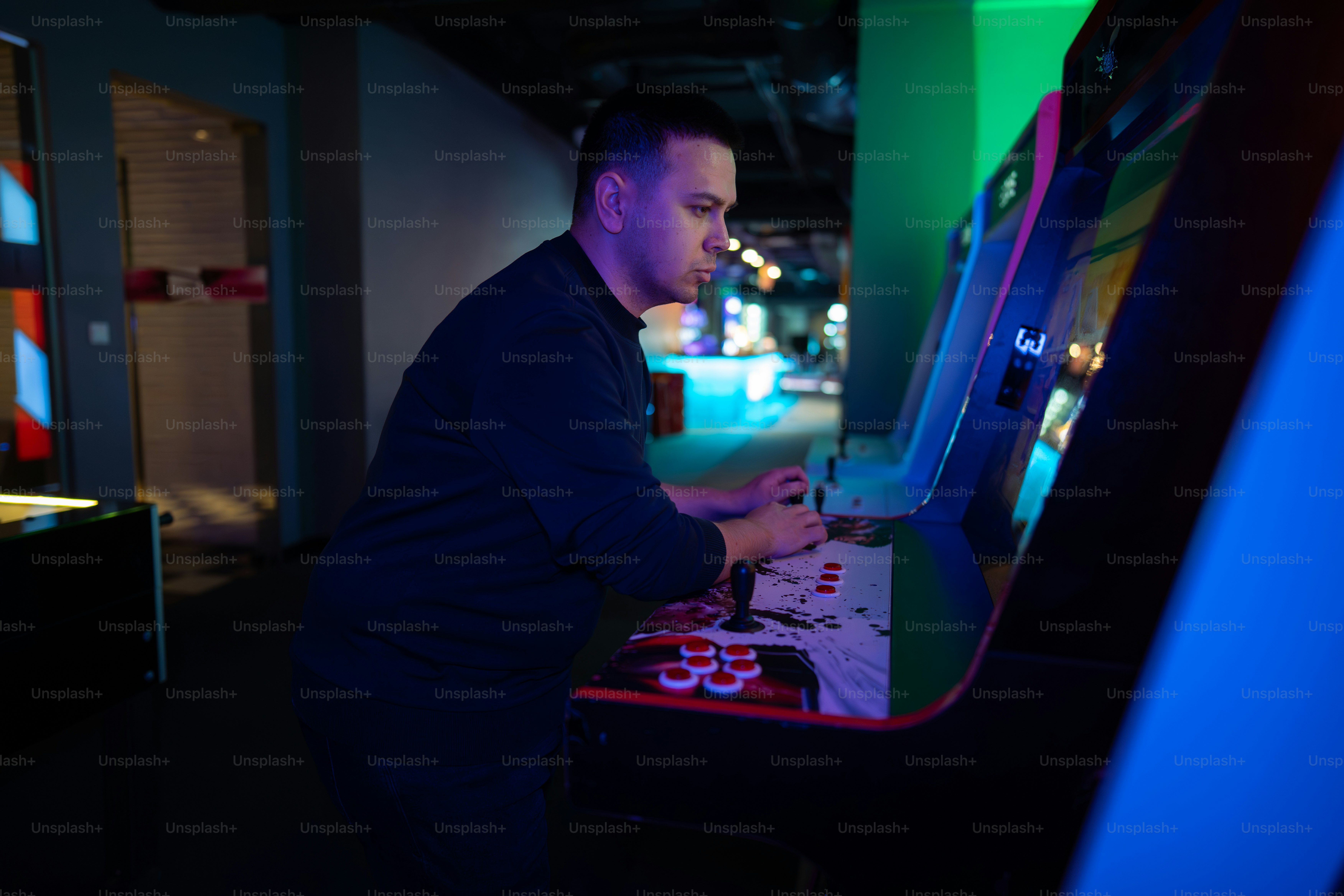 A man plays video games at an arcade. photo – Gaming Image on Unsplash