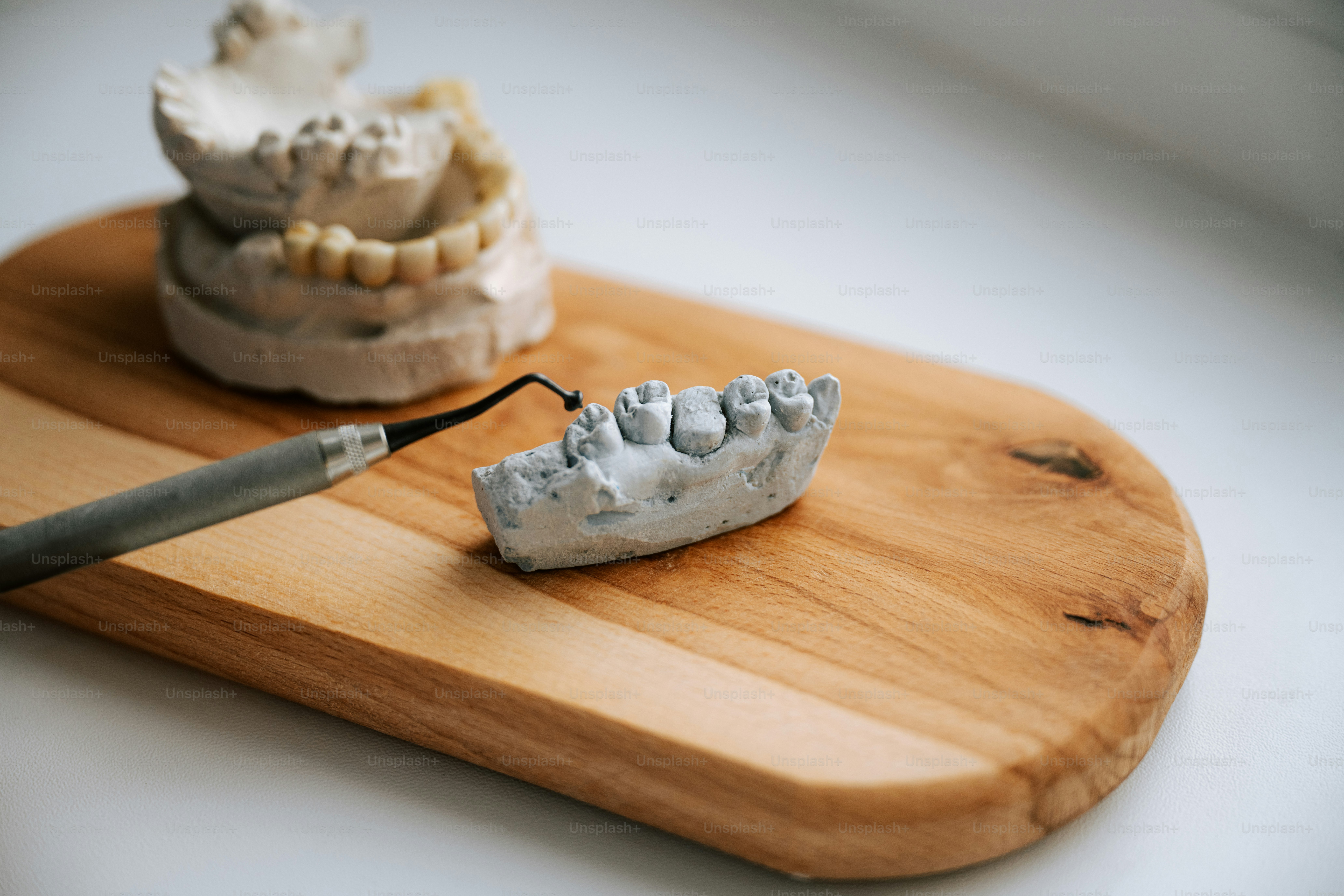 Les moules et les outils dentaires reposent sur une planche de bois.