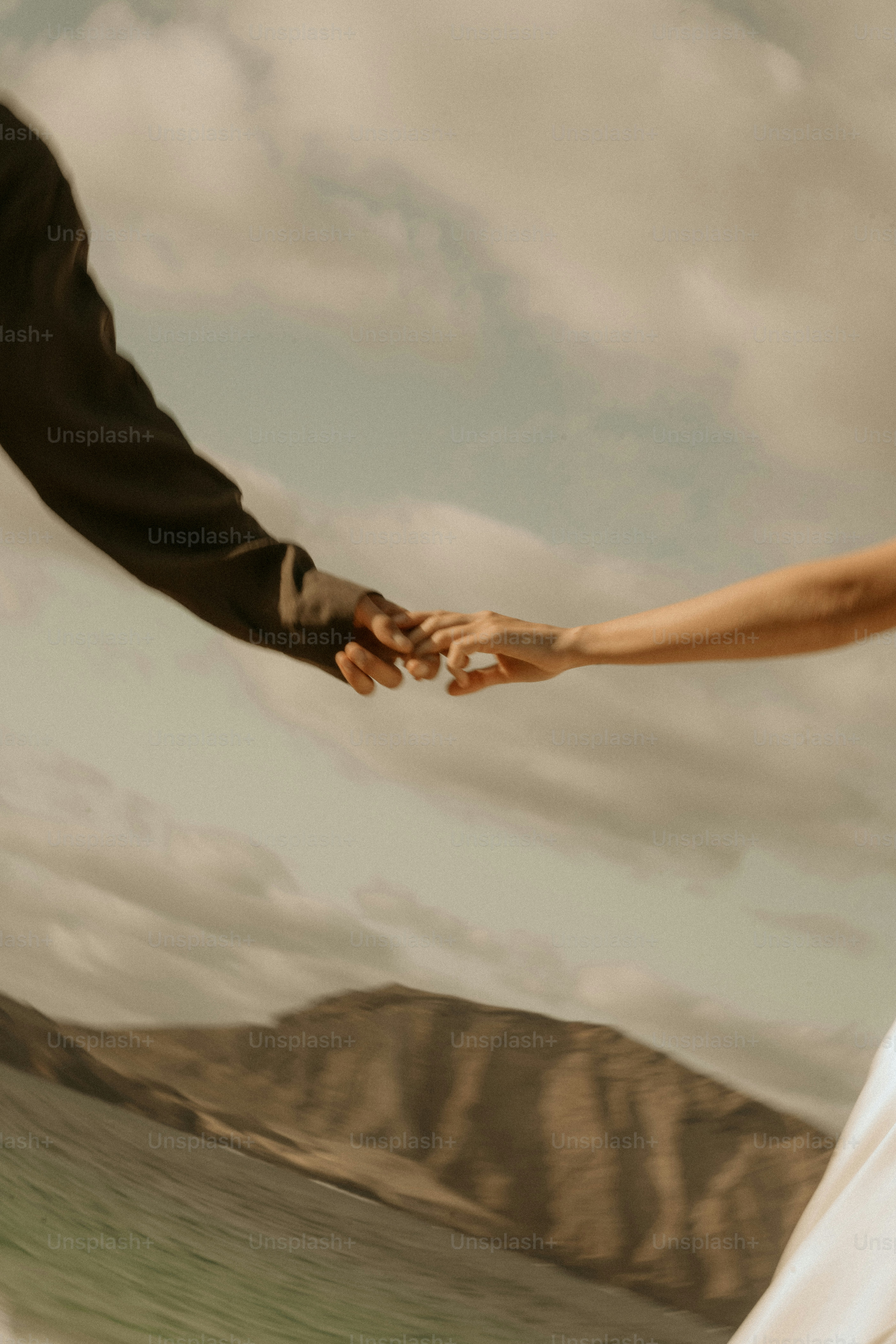 A couple holding hands, with a scenic view.