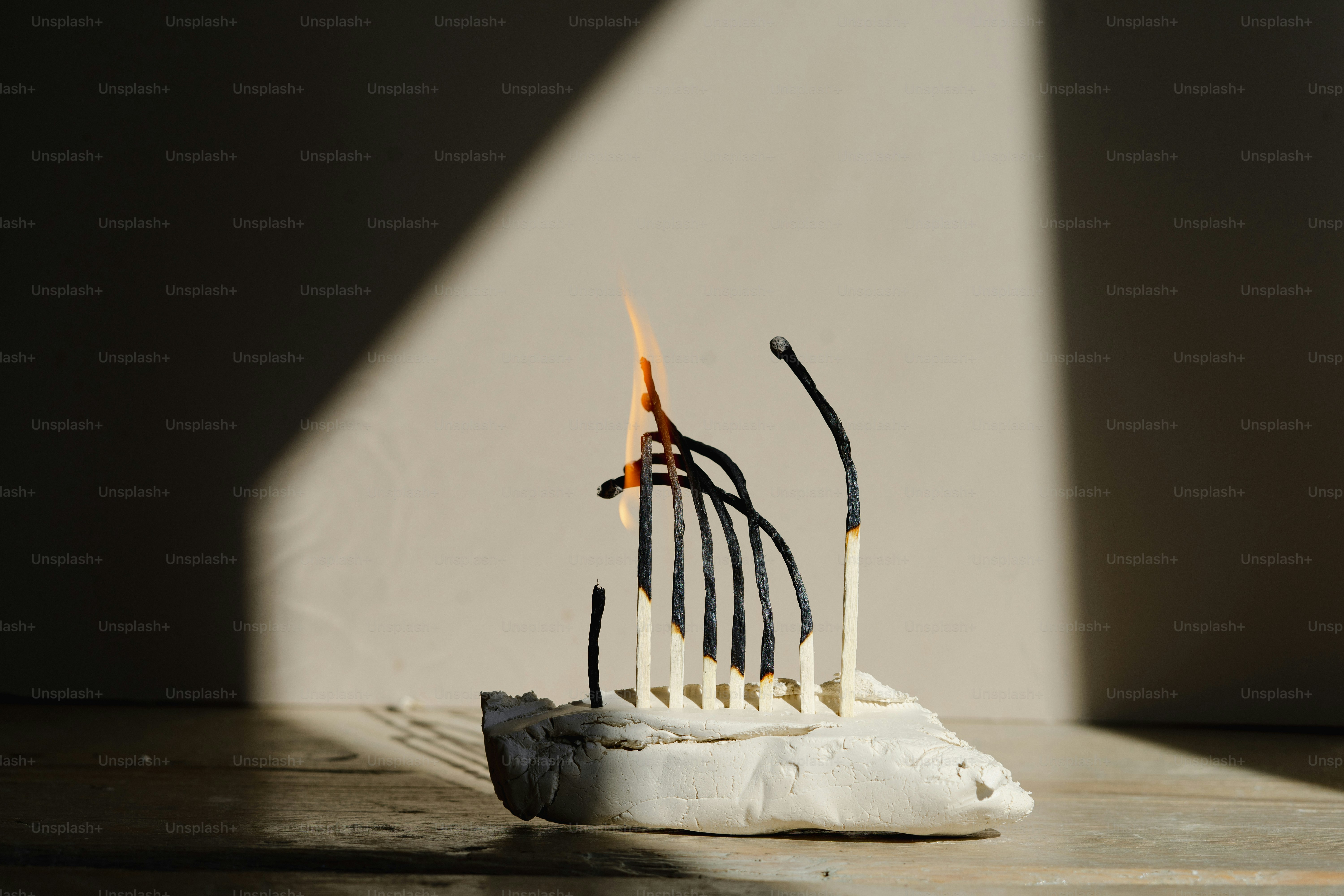 Brennende Streichhölzer, die so angeordnet sind, dass sie einem Boot ähneln.