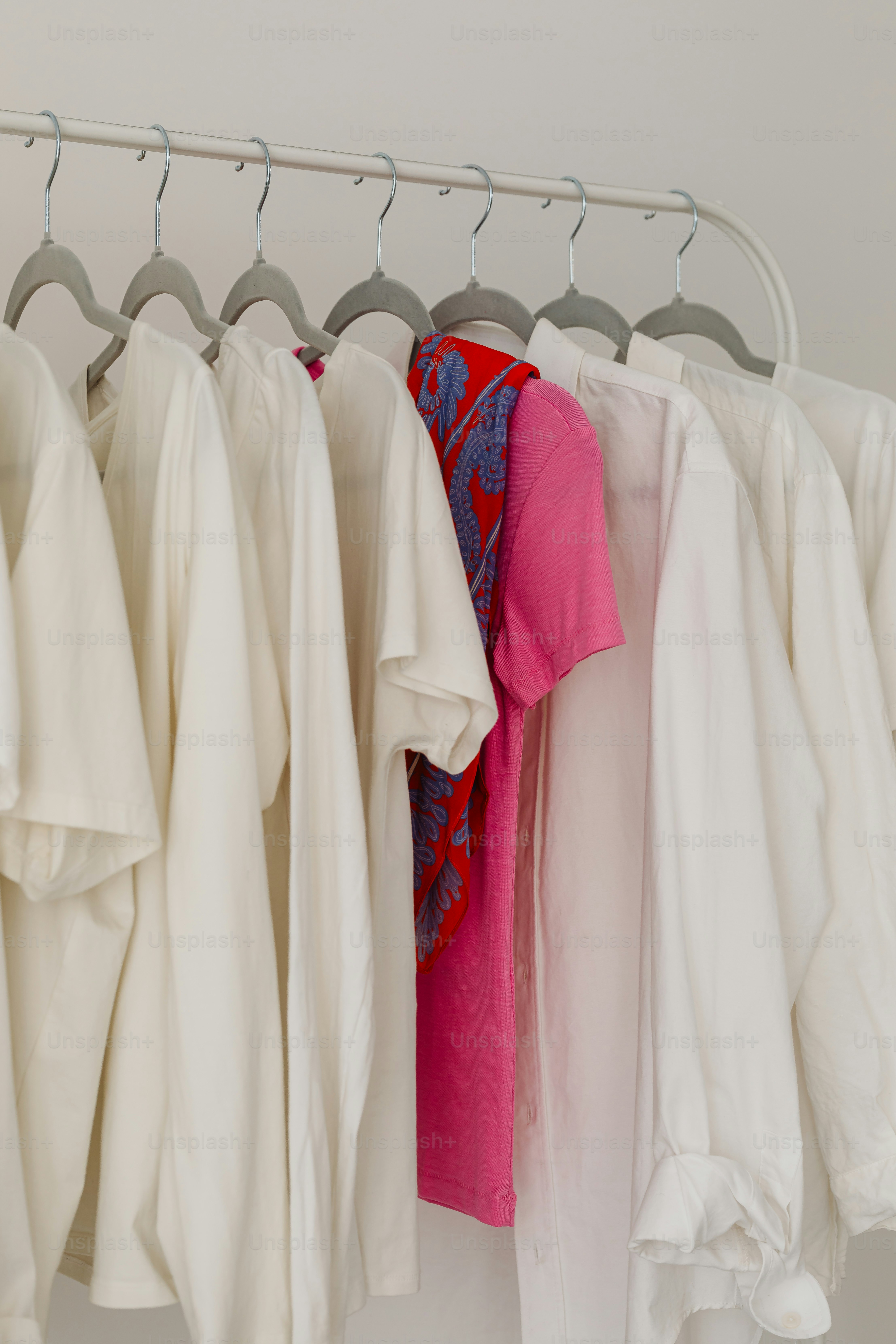 White shirts and a colorful shirt hang together.