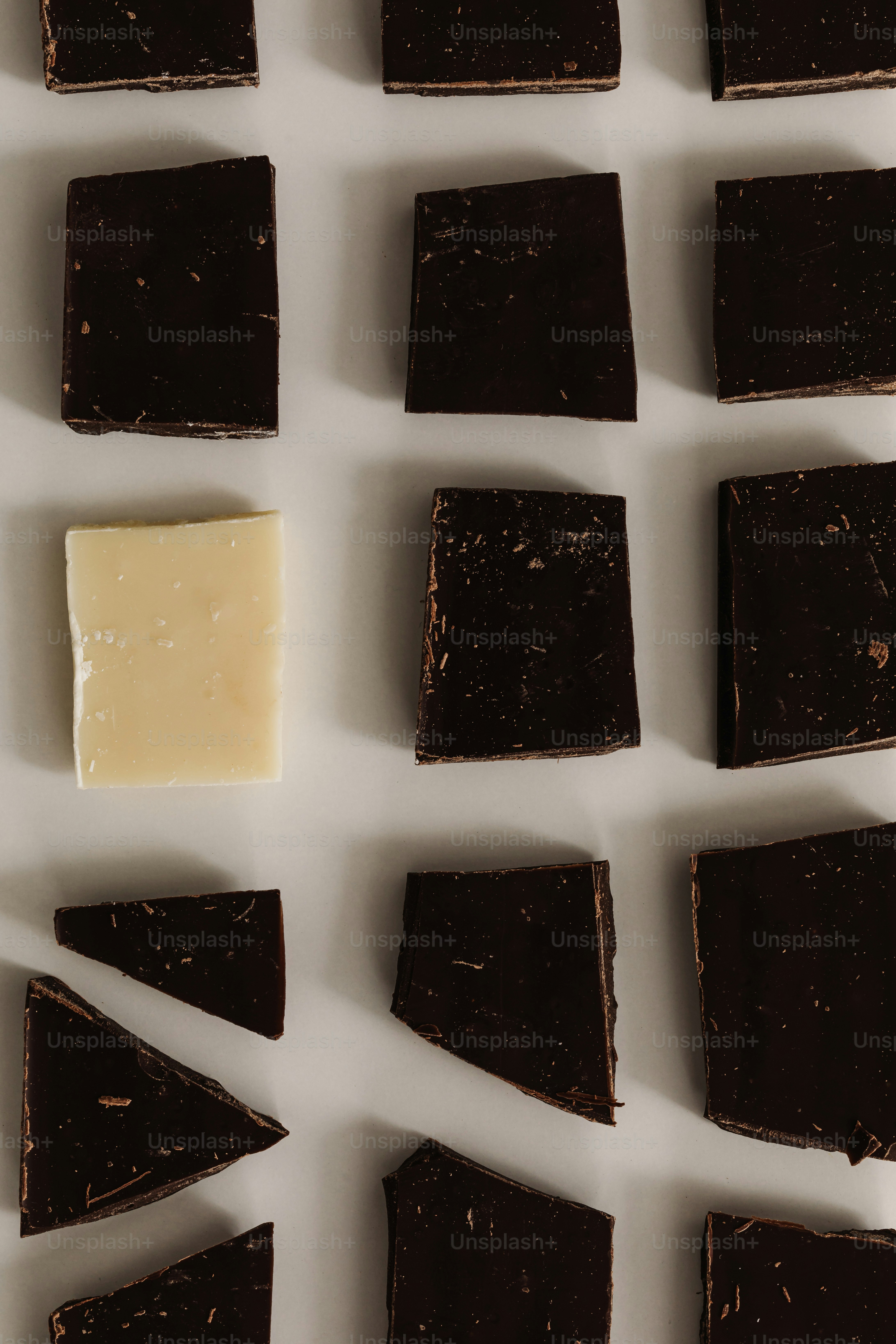 Dark chocolate pieces with one lighter cheese block.