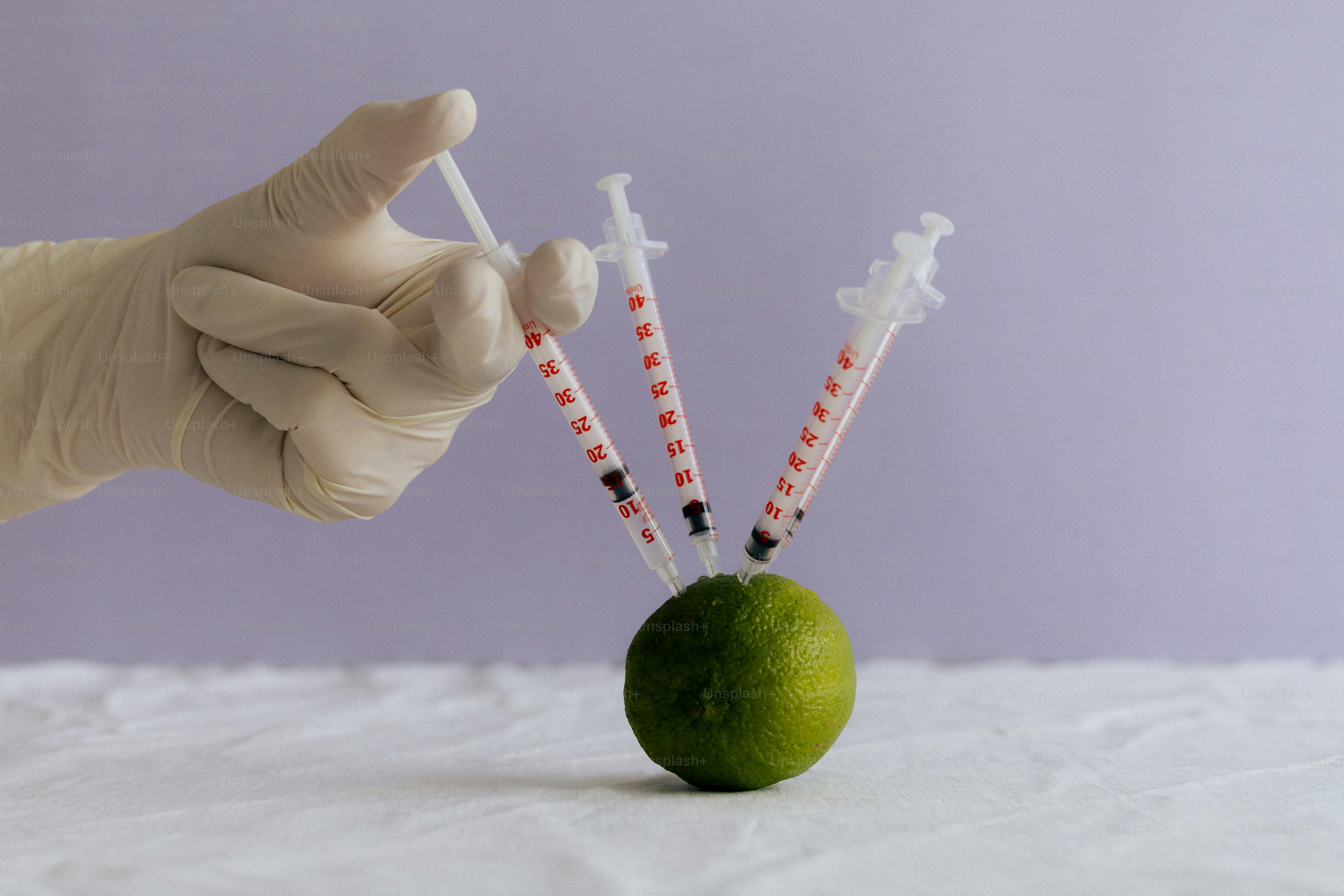 A lime is injected with multiple syringes.