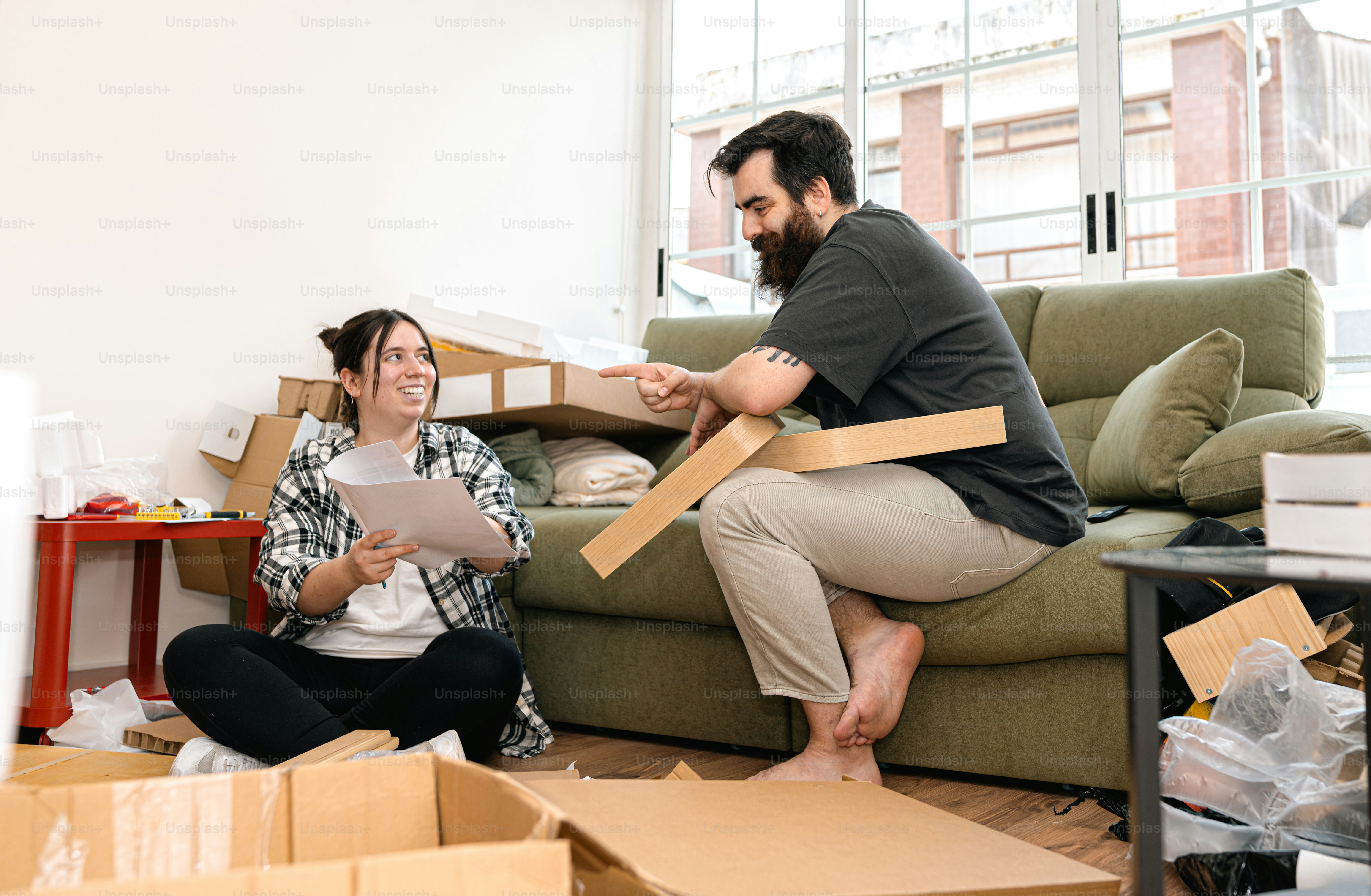 Couple assembling furniture in their new home.