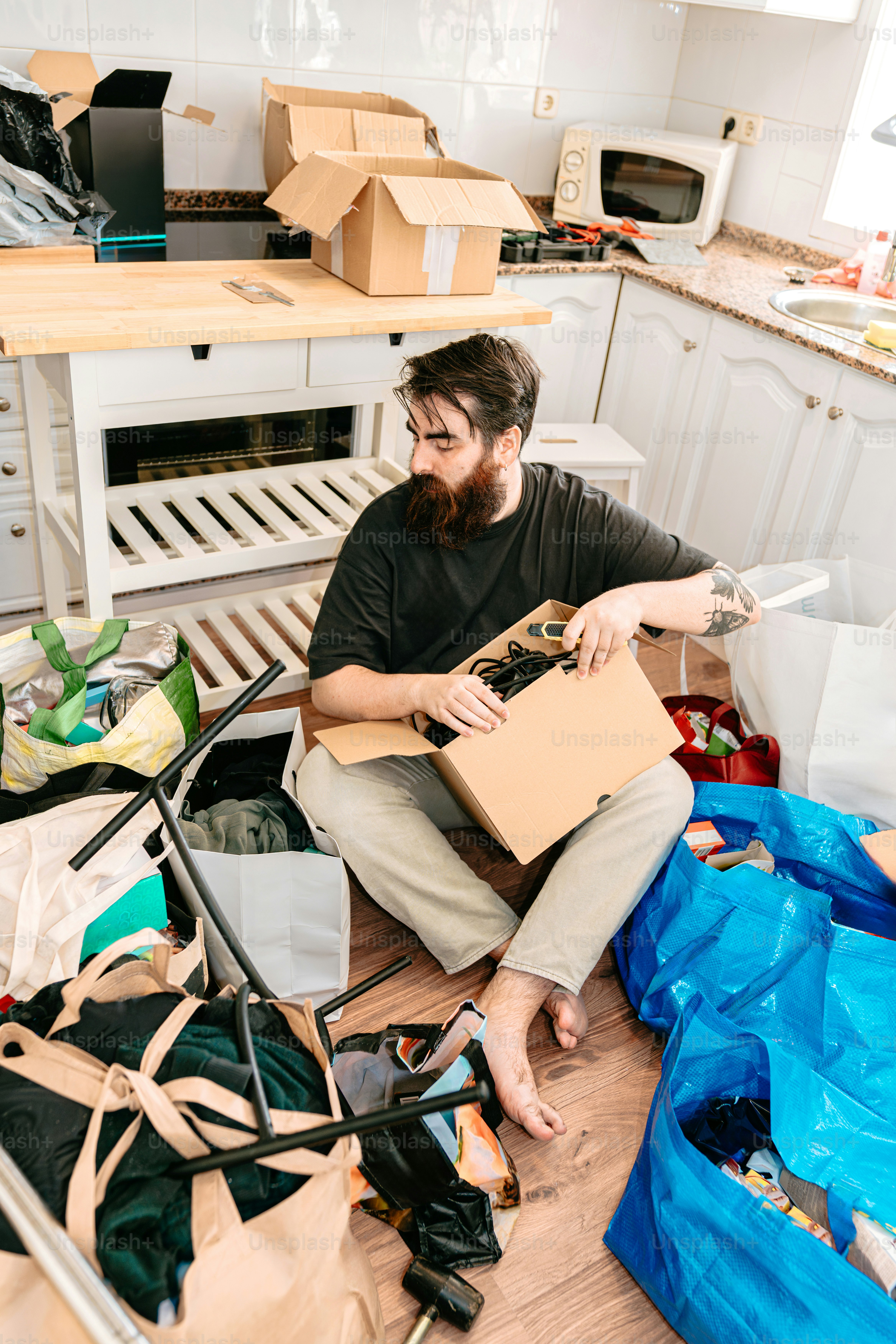 A man sorts through boxes while moving.