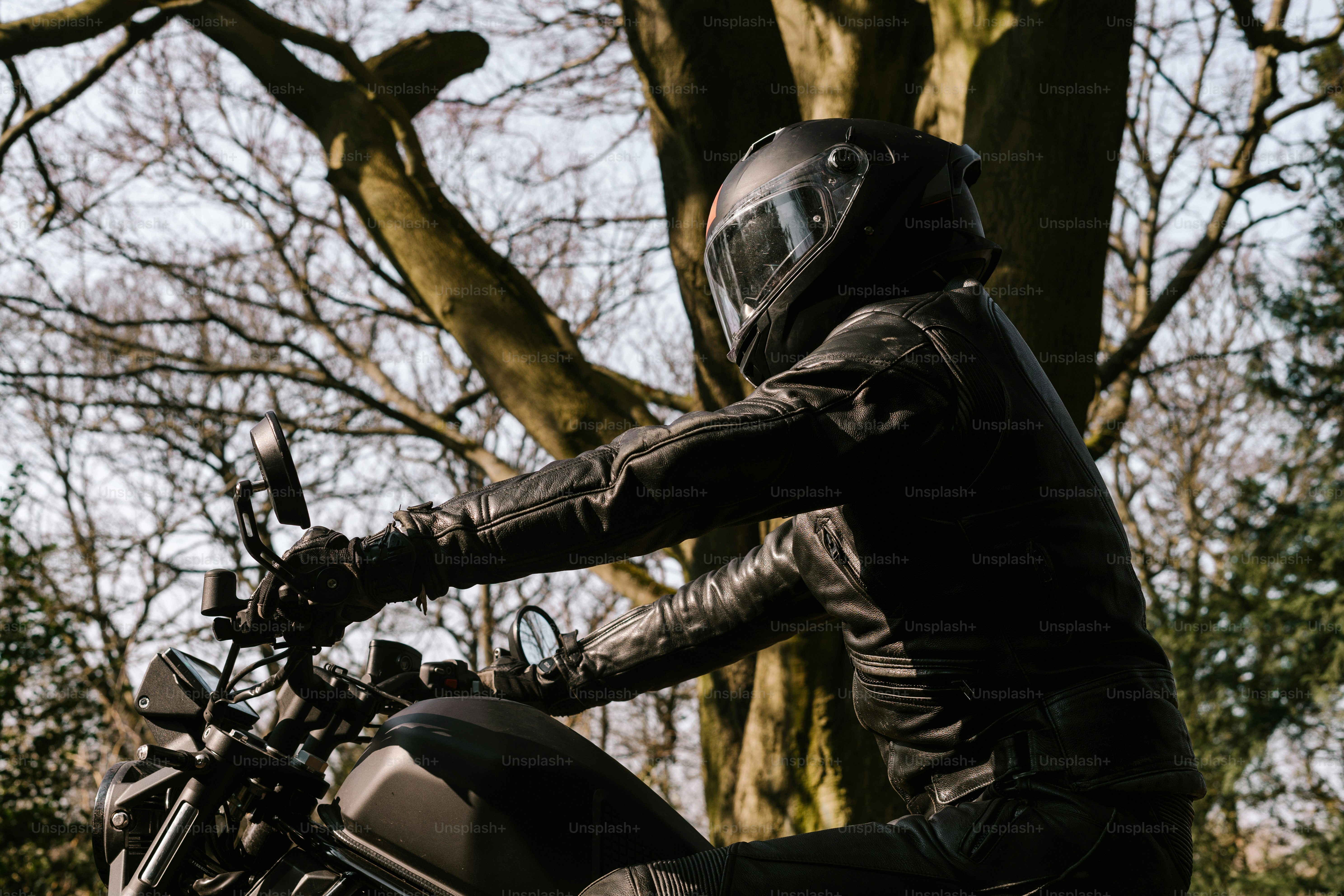 Motorcyclist in a helmet riding through a forest.