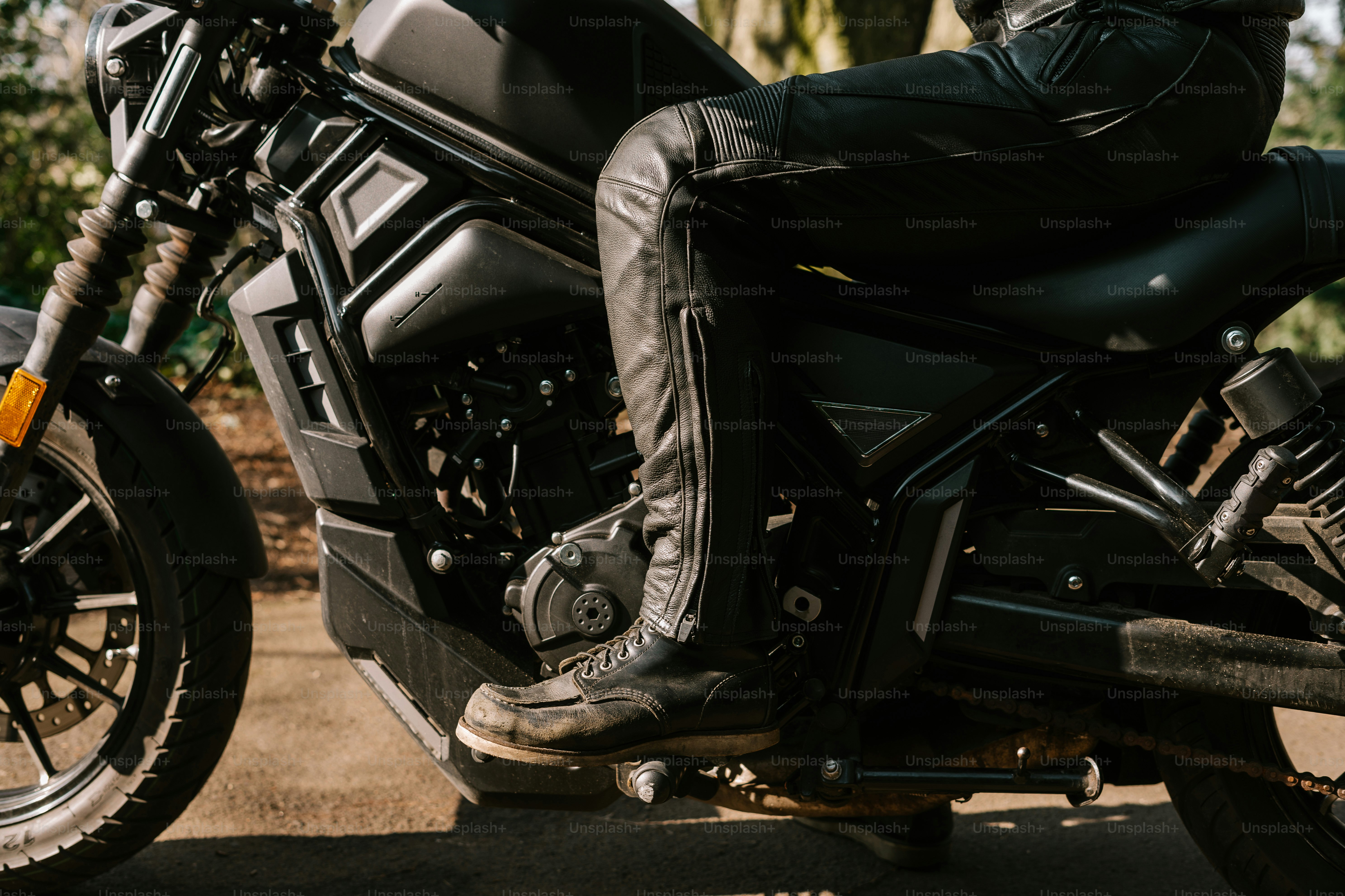 A person is riding a stylish black motorcycle.