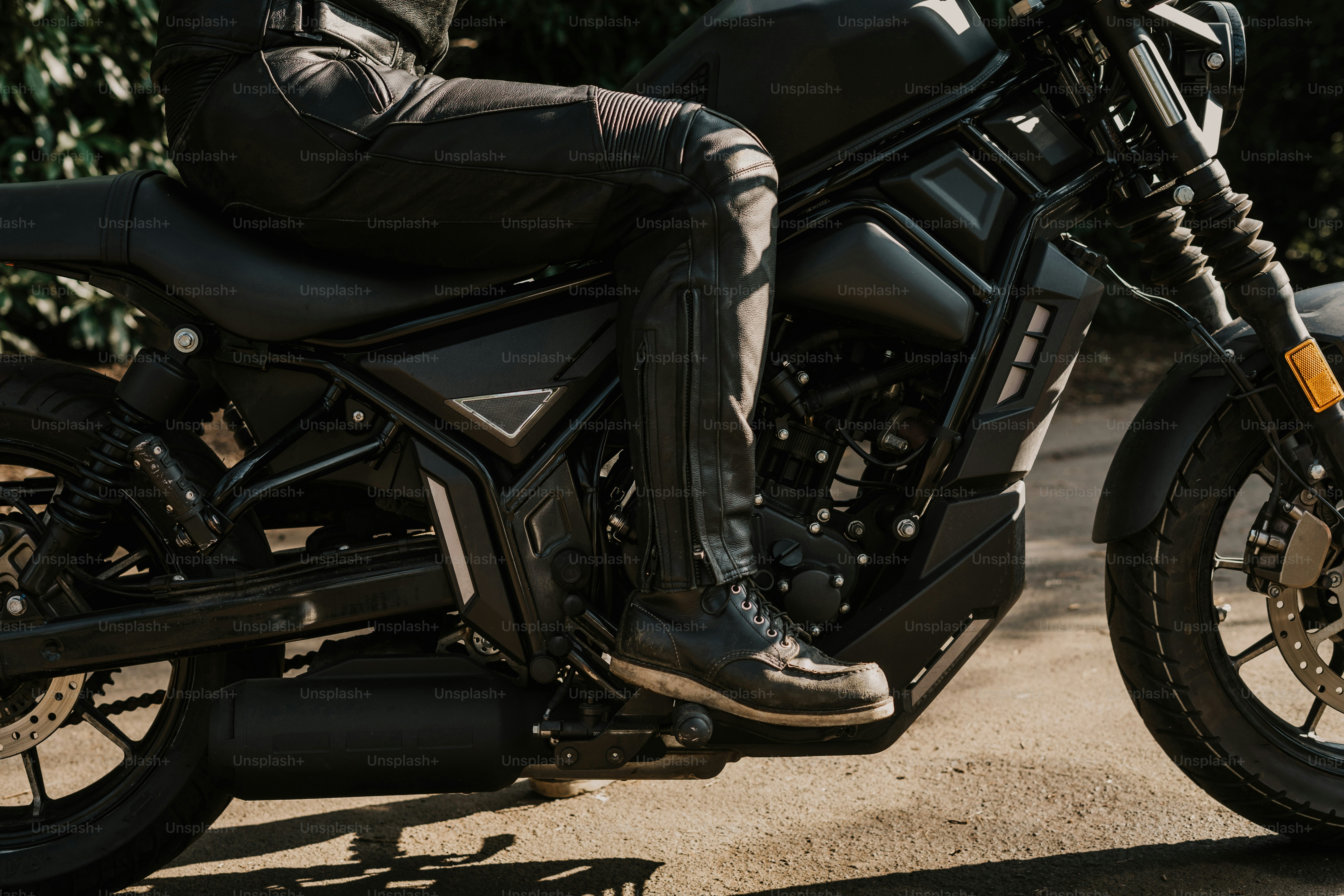 Conductor en una motocicleta negra, vestido con ropa de cuero