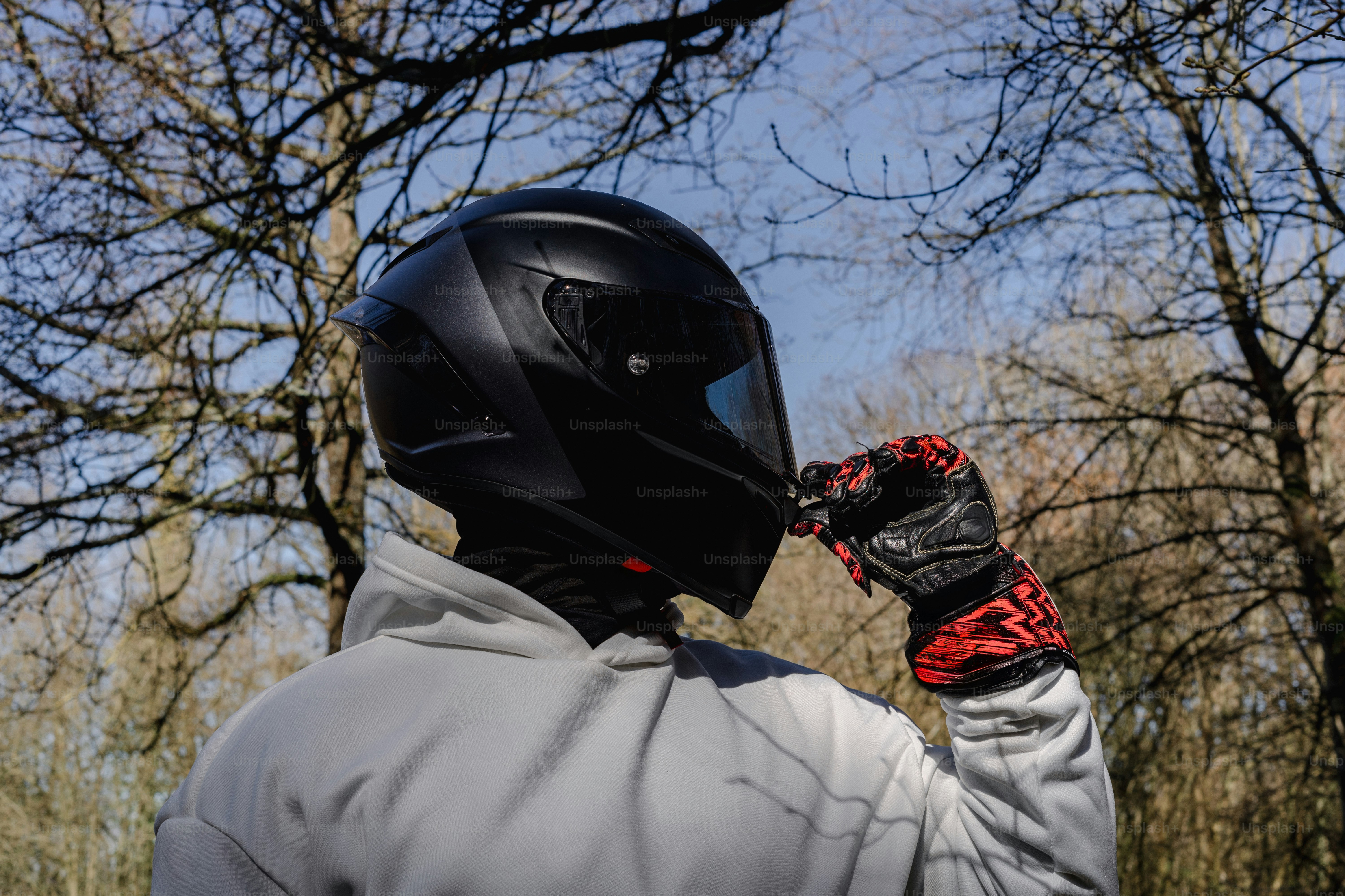 屋外でオートバイのヘルメットをかぶっている人。