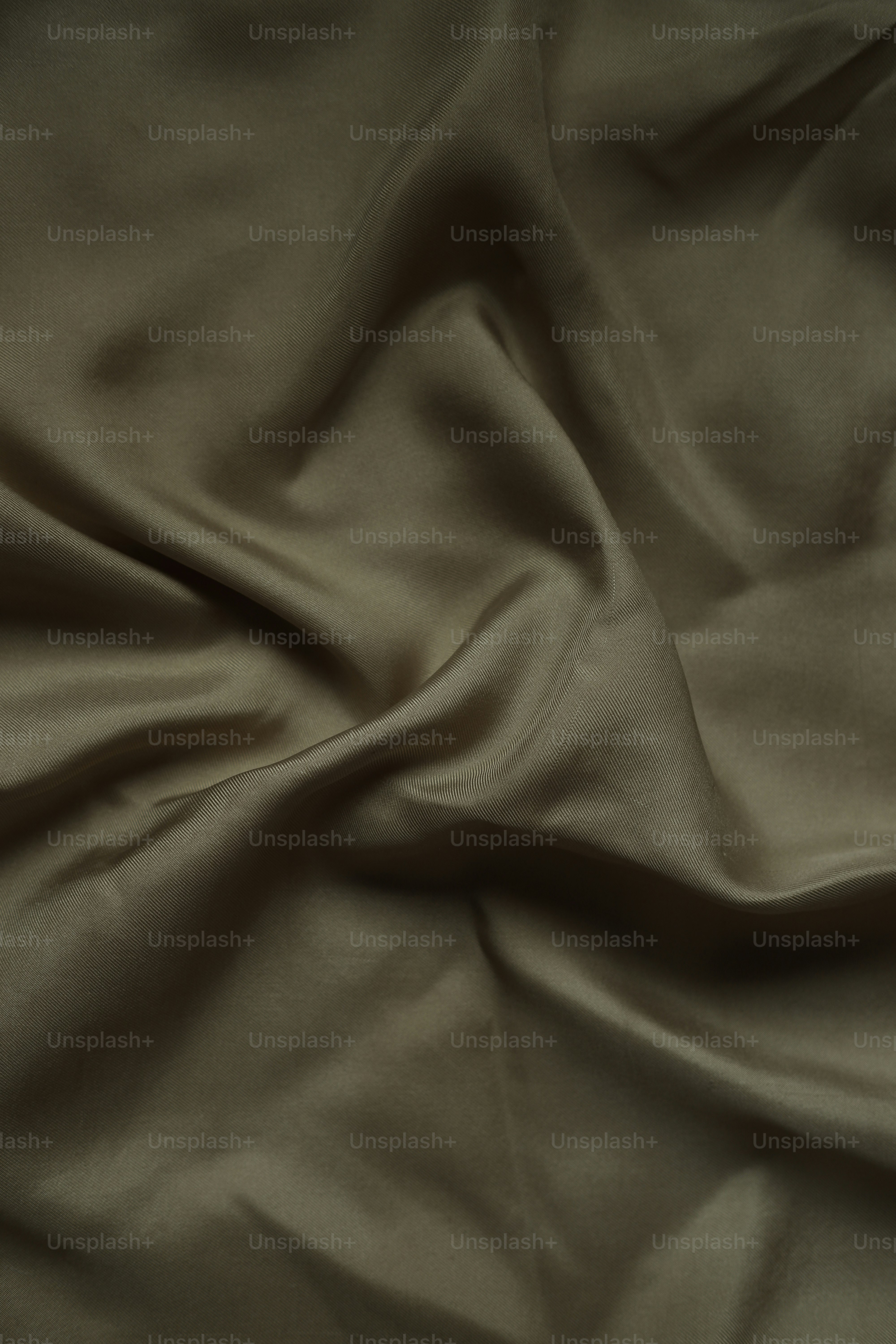 Weicher, goldbrauner Stoff drapiert sich im Licht.