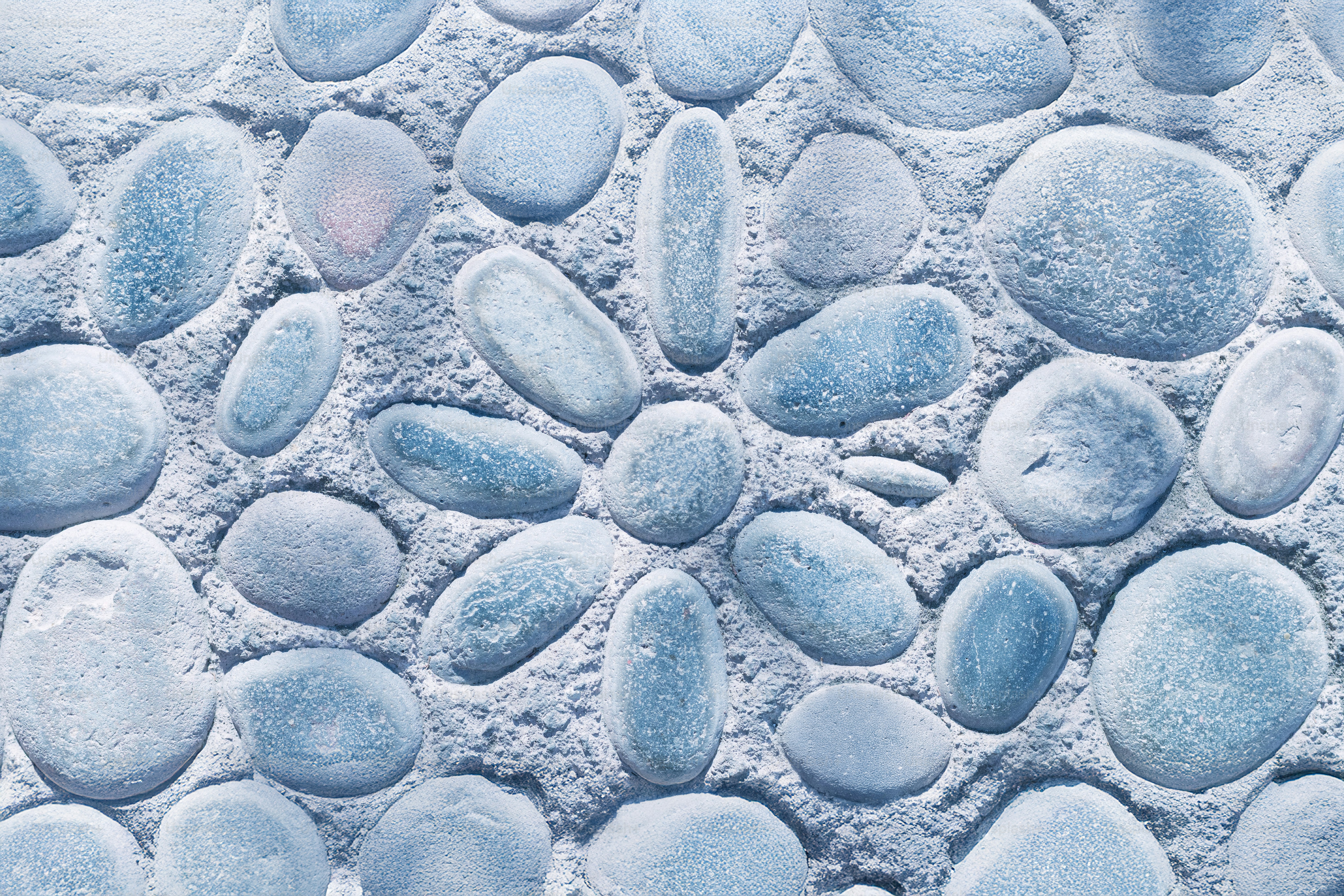 Blue pebbles arranged into a flower design.