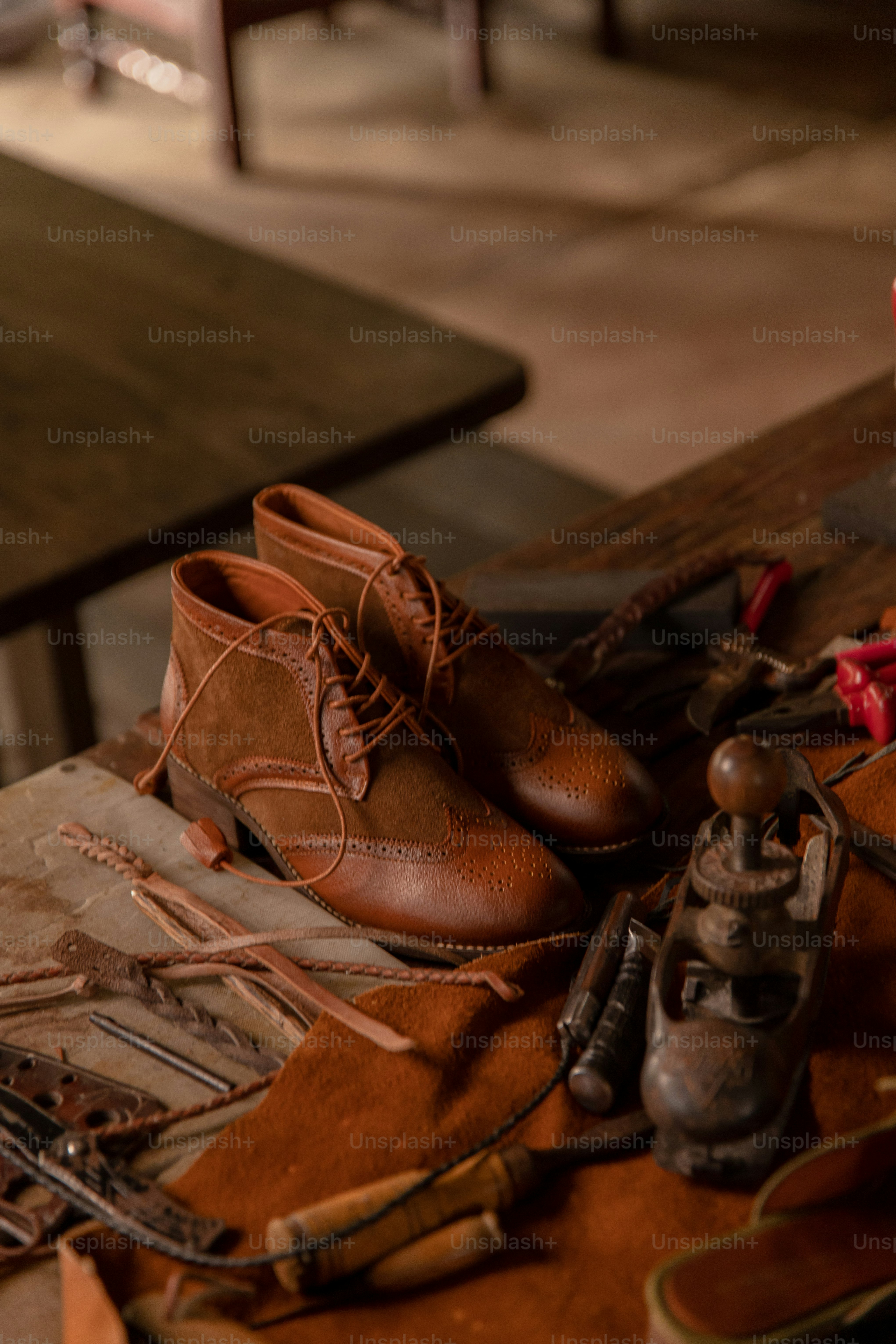 Handcrafted shoes rest on a cobbler's work table.