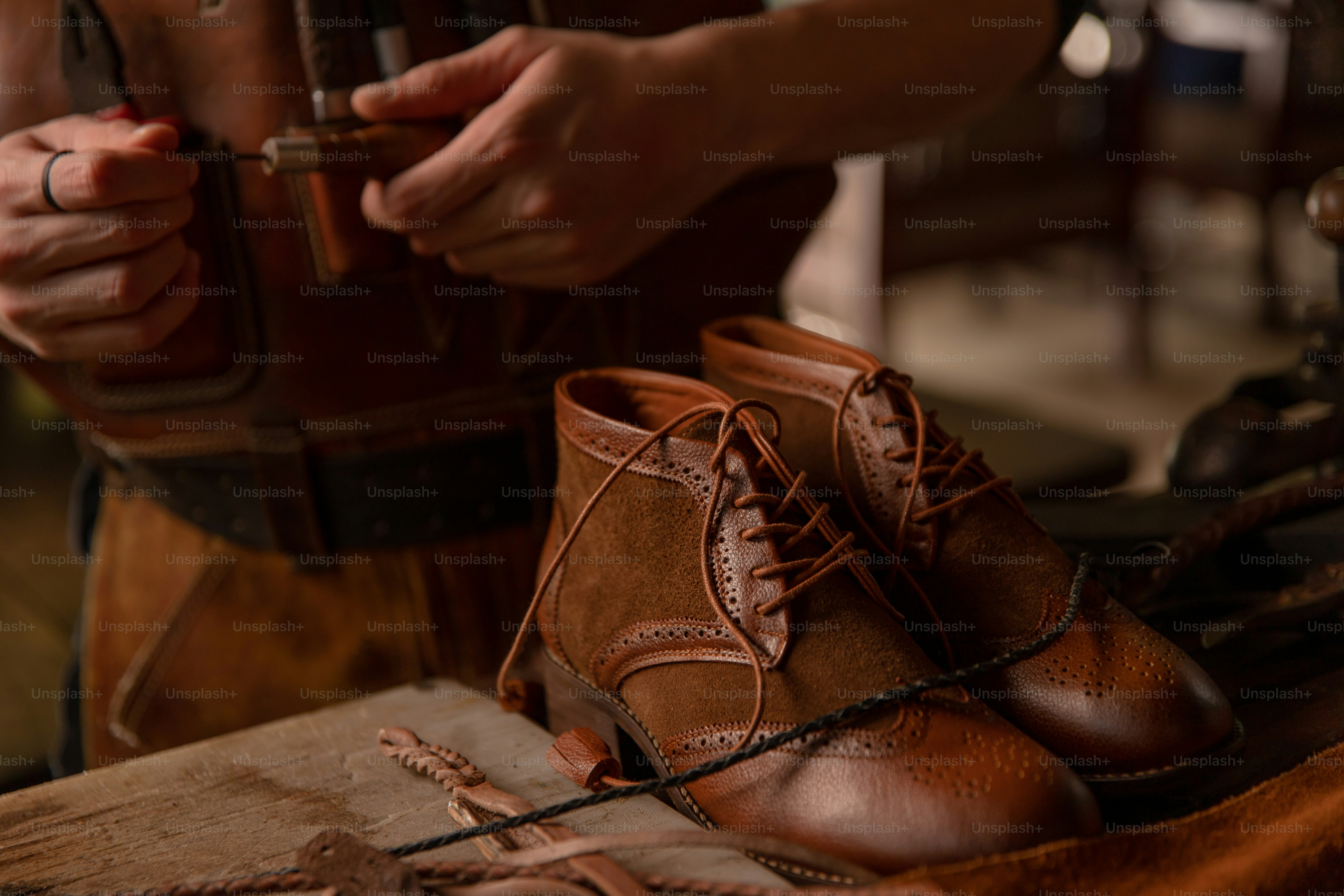 A cobbler works on crafting leather shoes.