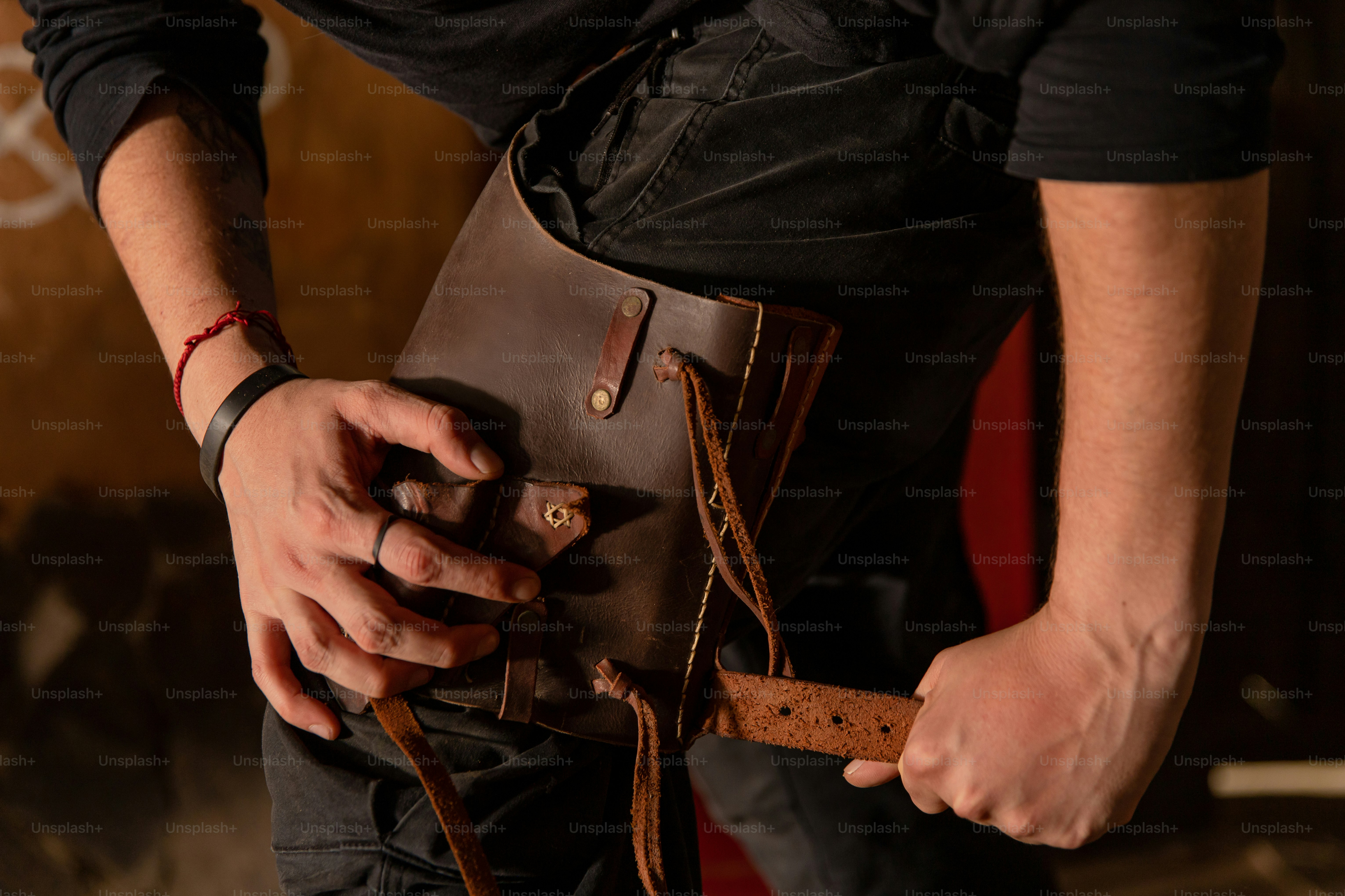 Man is holding a leather bag.
