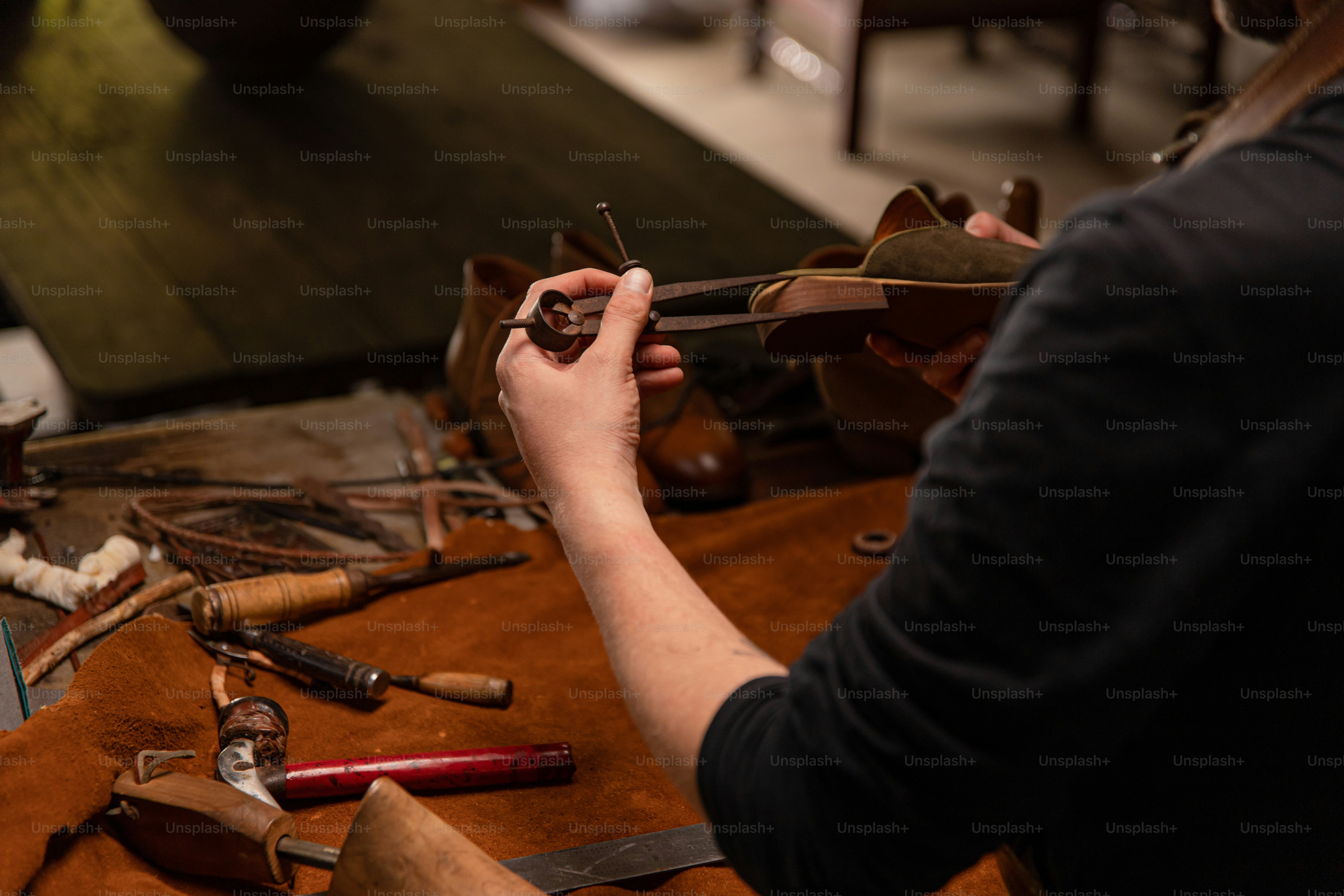 A cobbler works on a leather shoe.