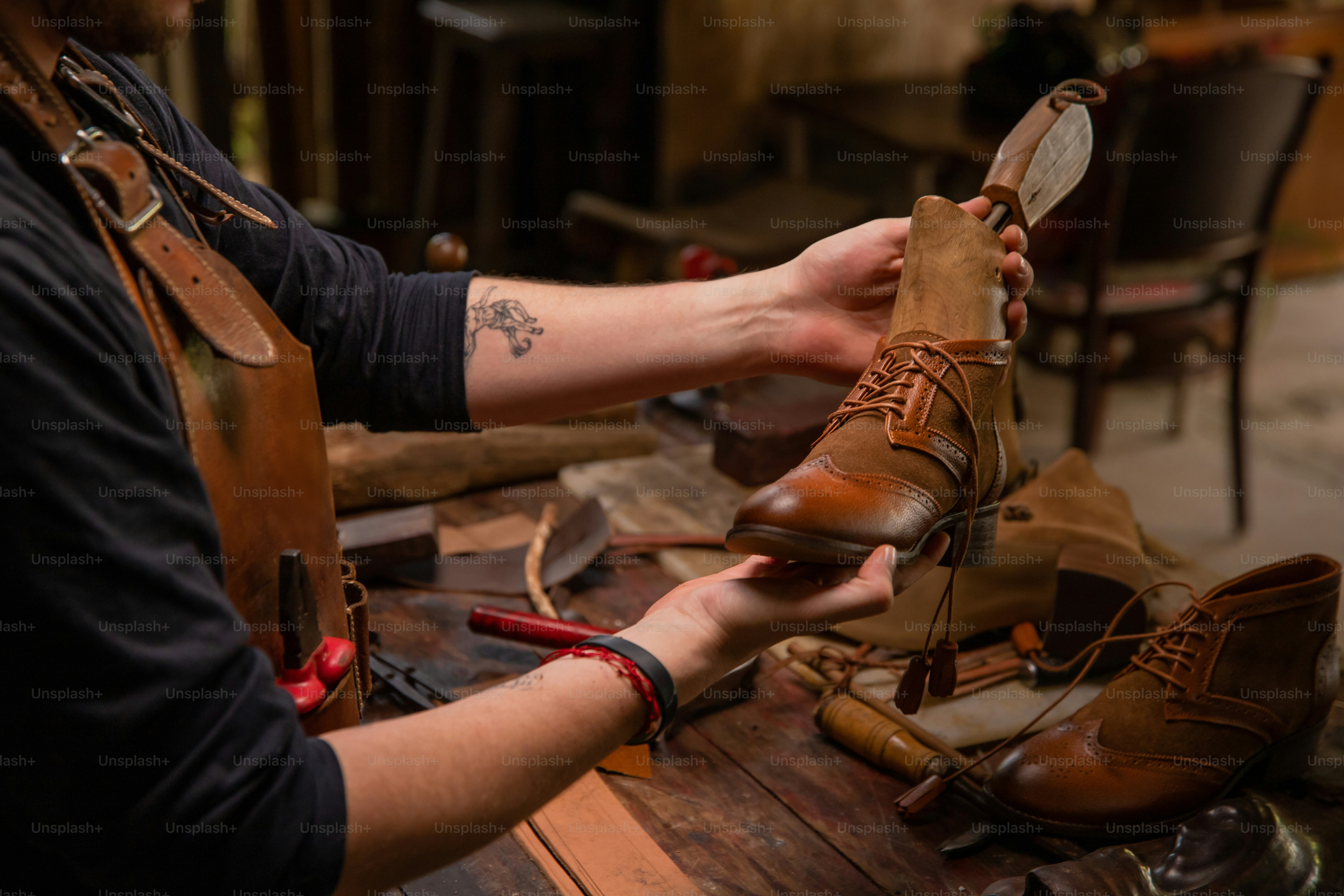 A shoemaker is crafting a leather boot.