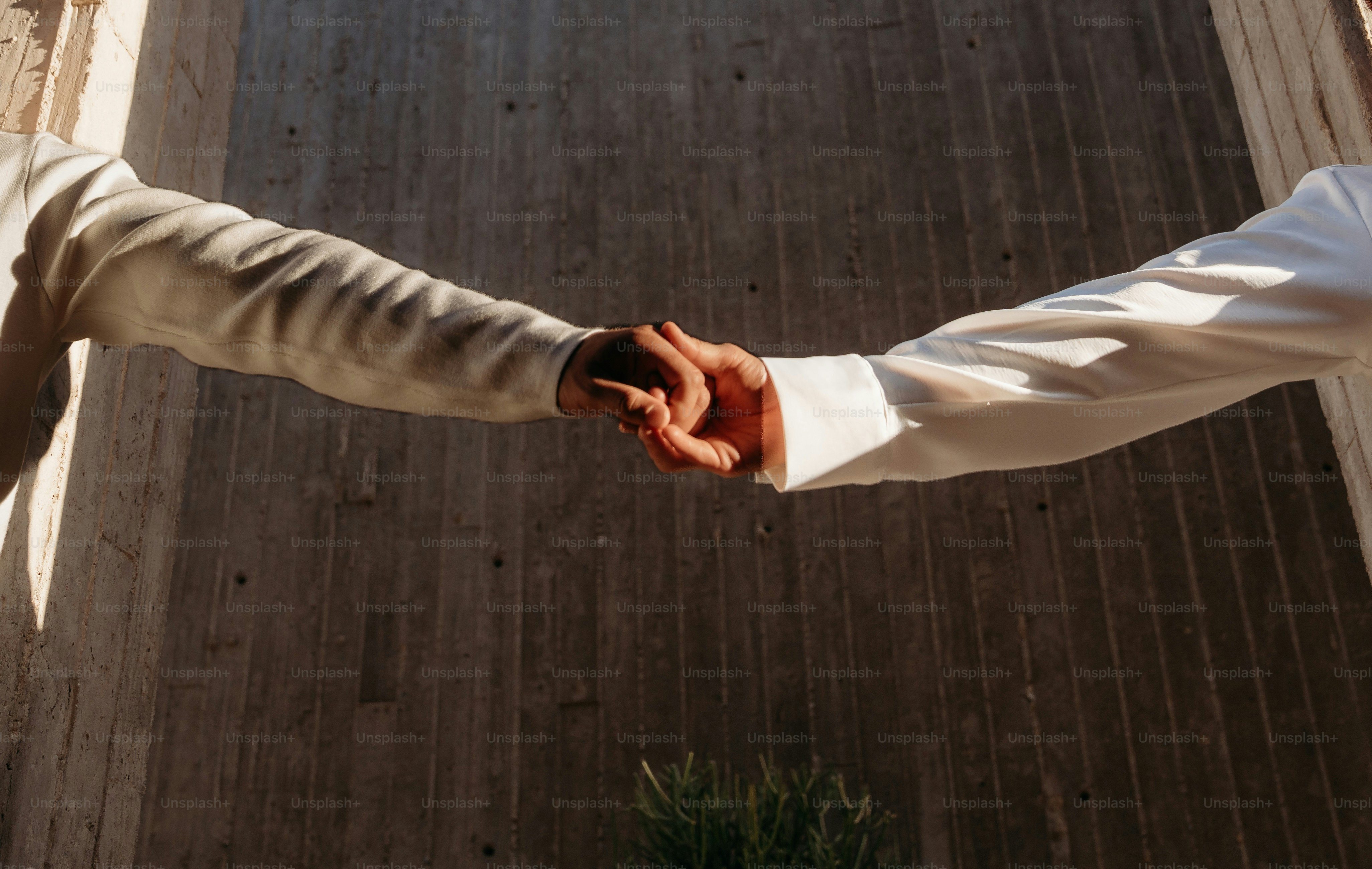 Two people holding hands in unity.