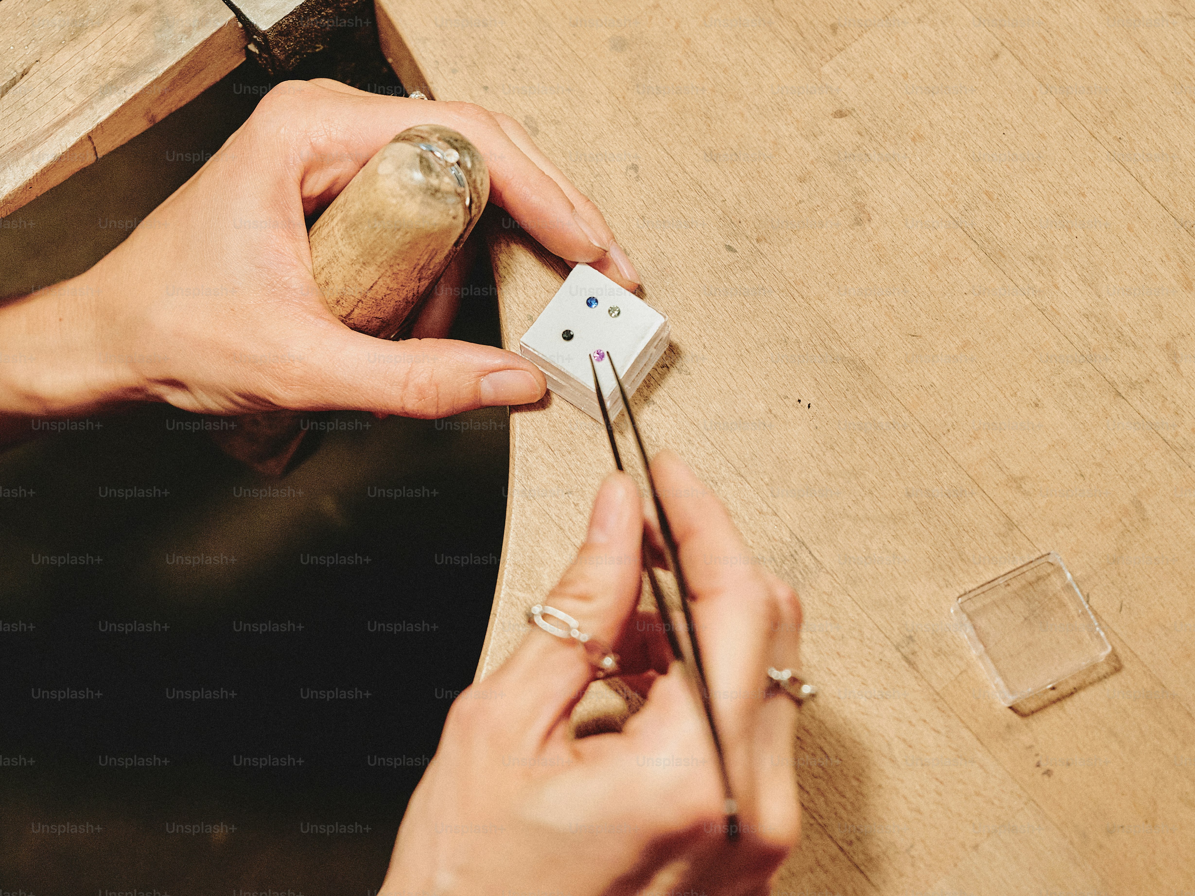 Jeweler uses tweezers to set gemstones.