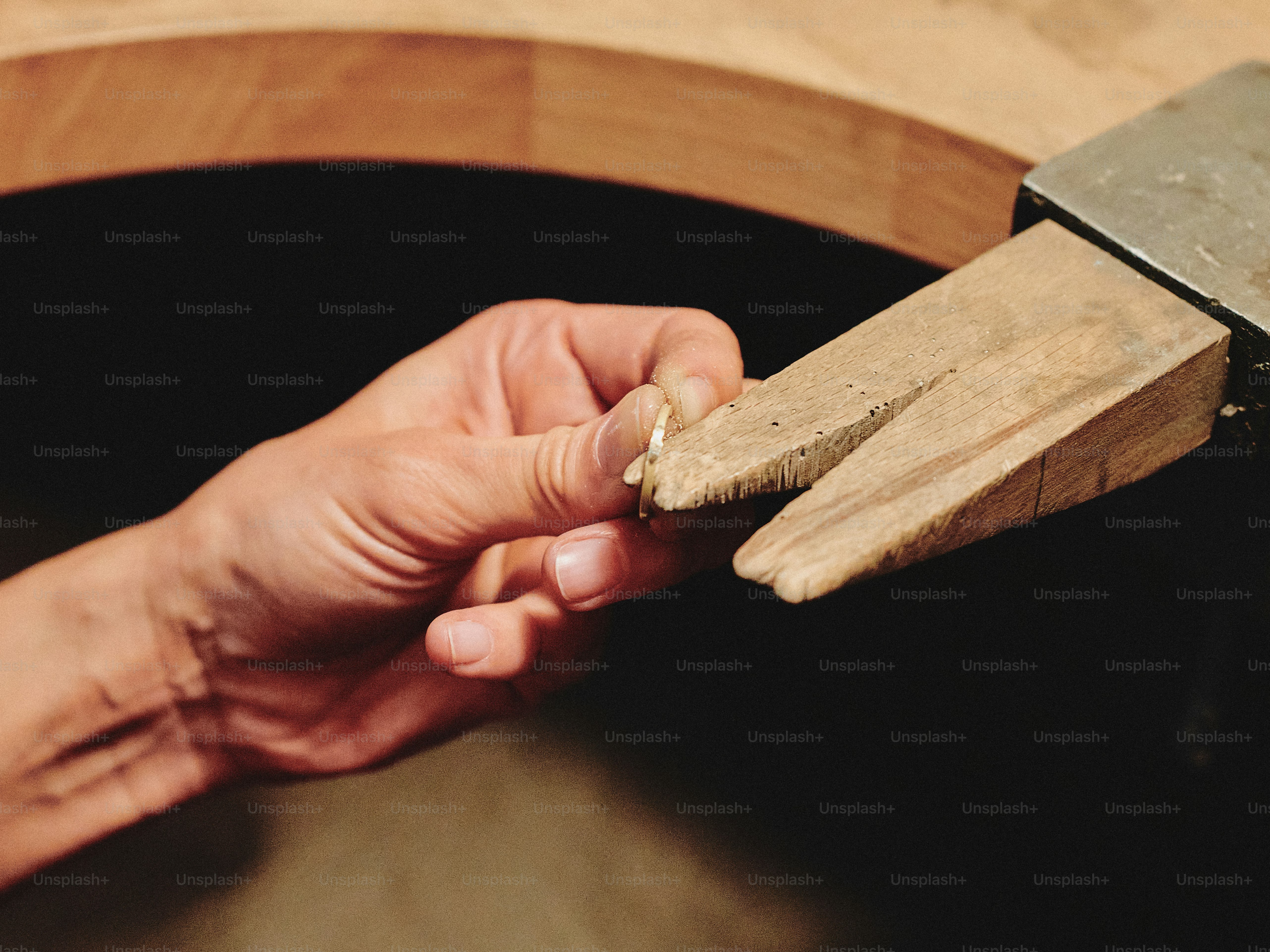 Jeweler inspecting a ring with a wooden vise