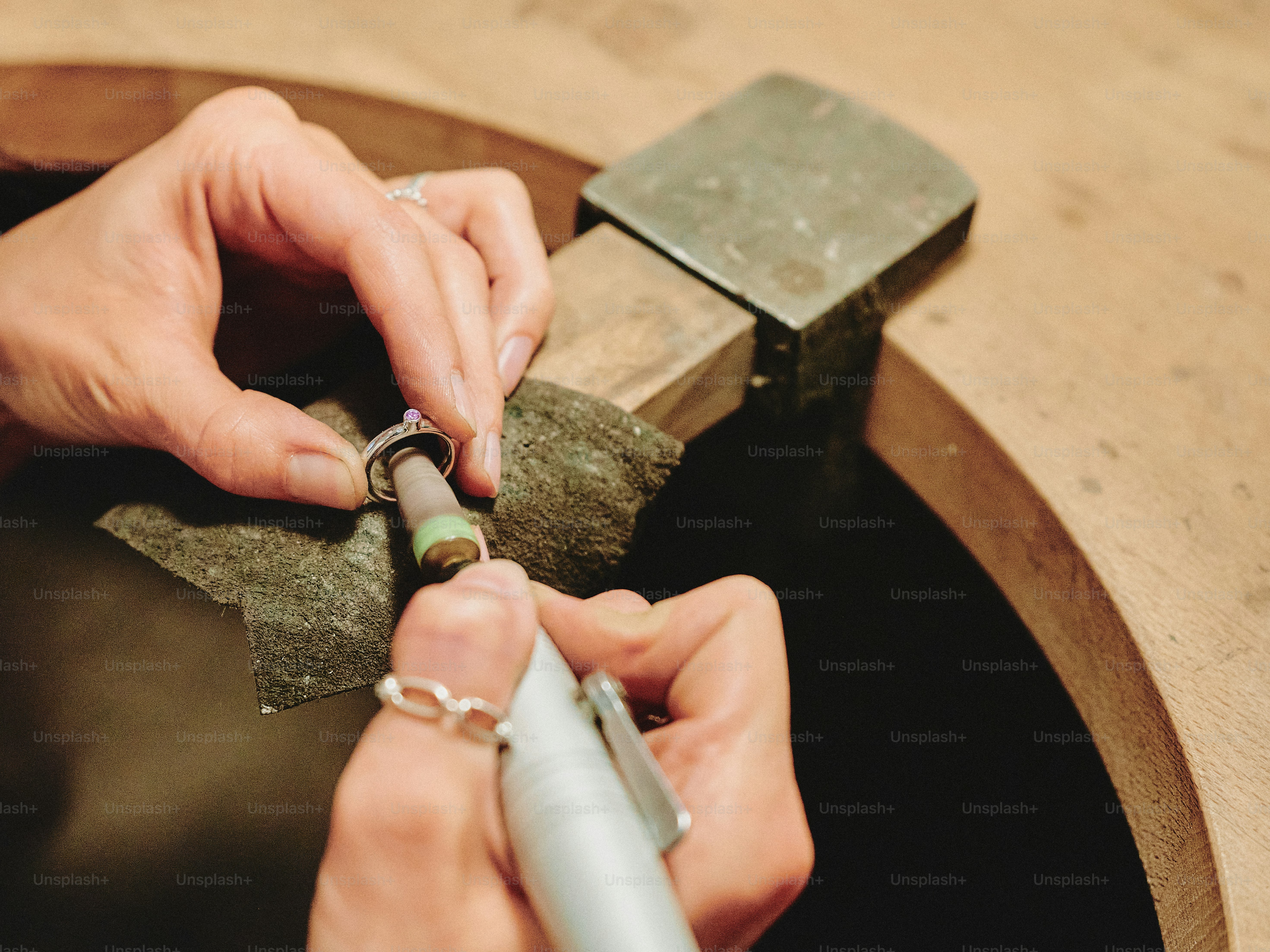 Jeweler is polishing a gemstone with a tool.
