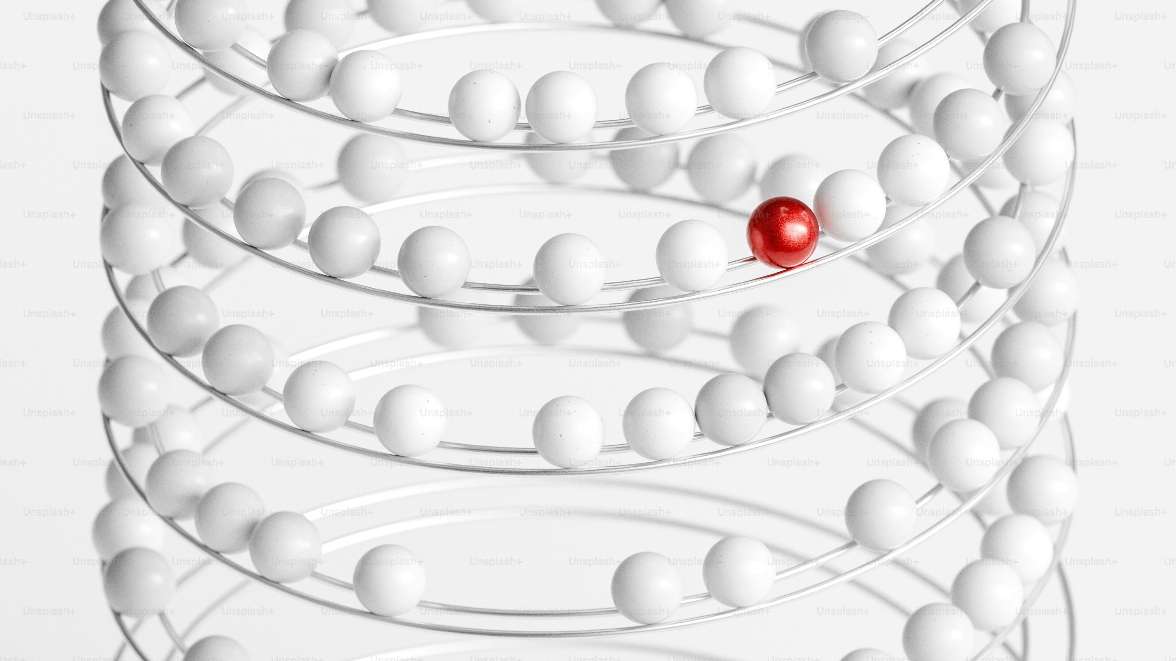 A red ball is surrounded by white spheres.