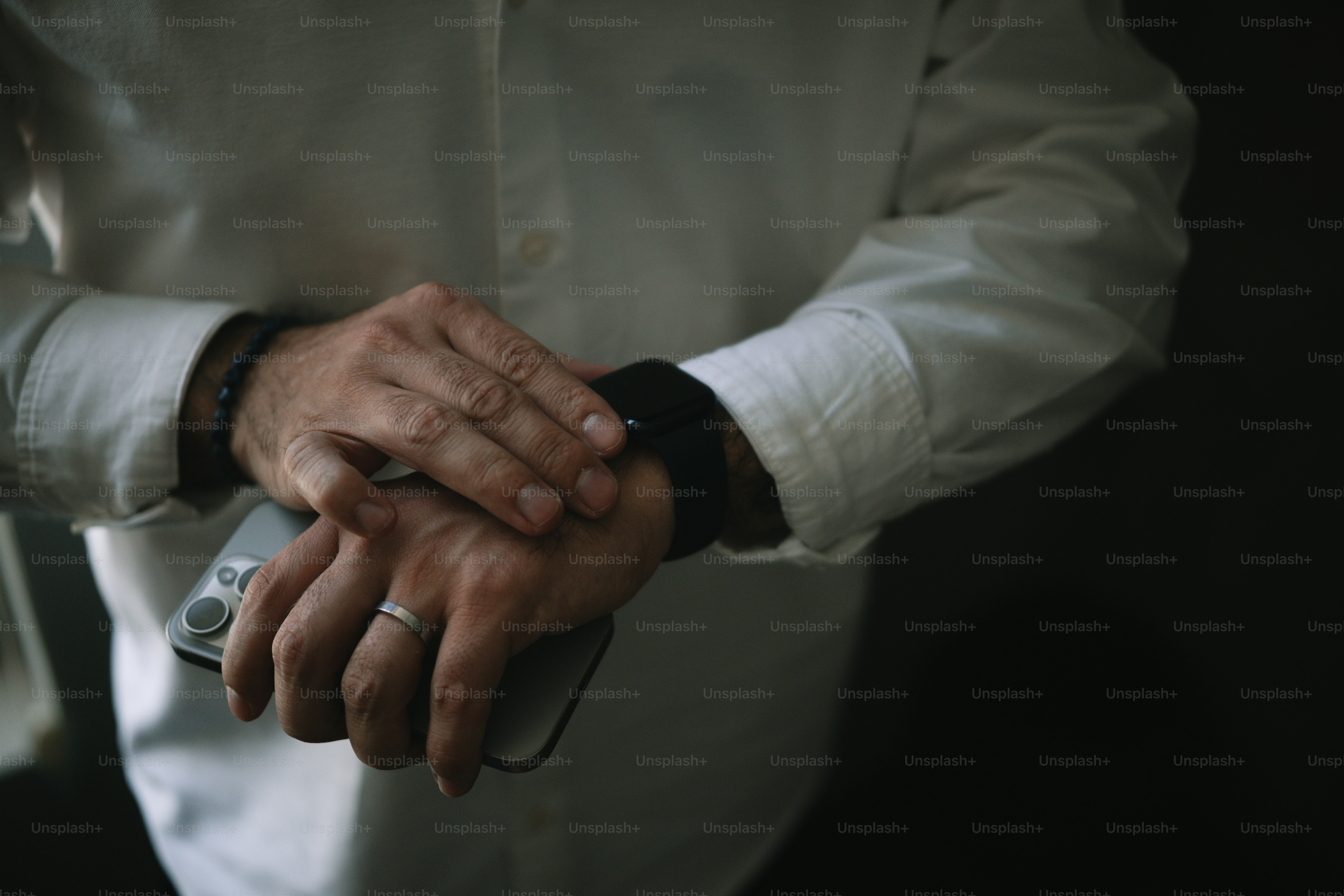 A man is checking his watch and phone.