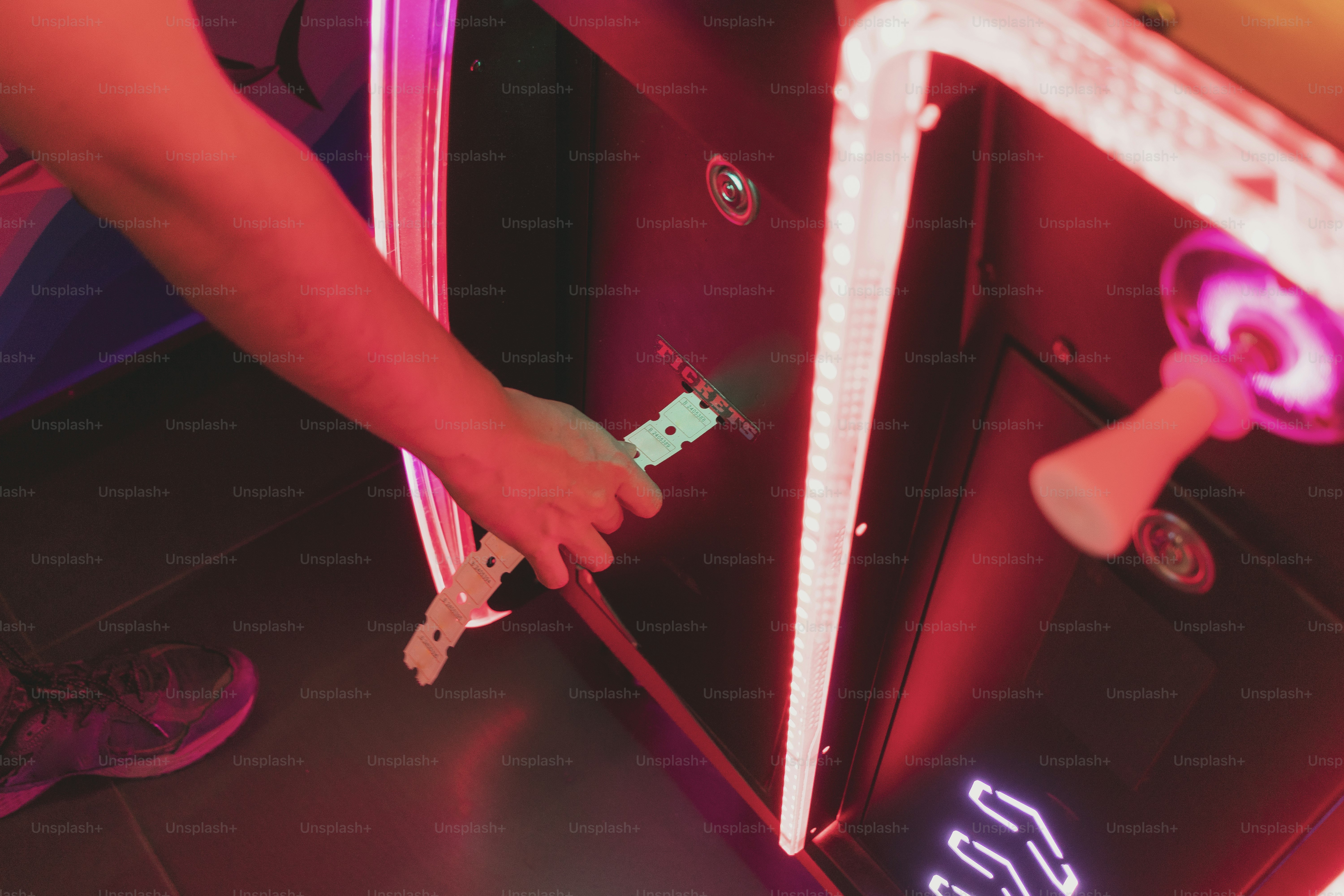 Someone is inserting a token into a game machine.