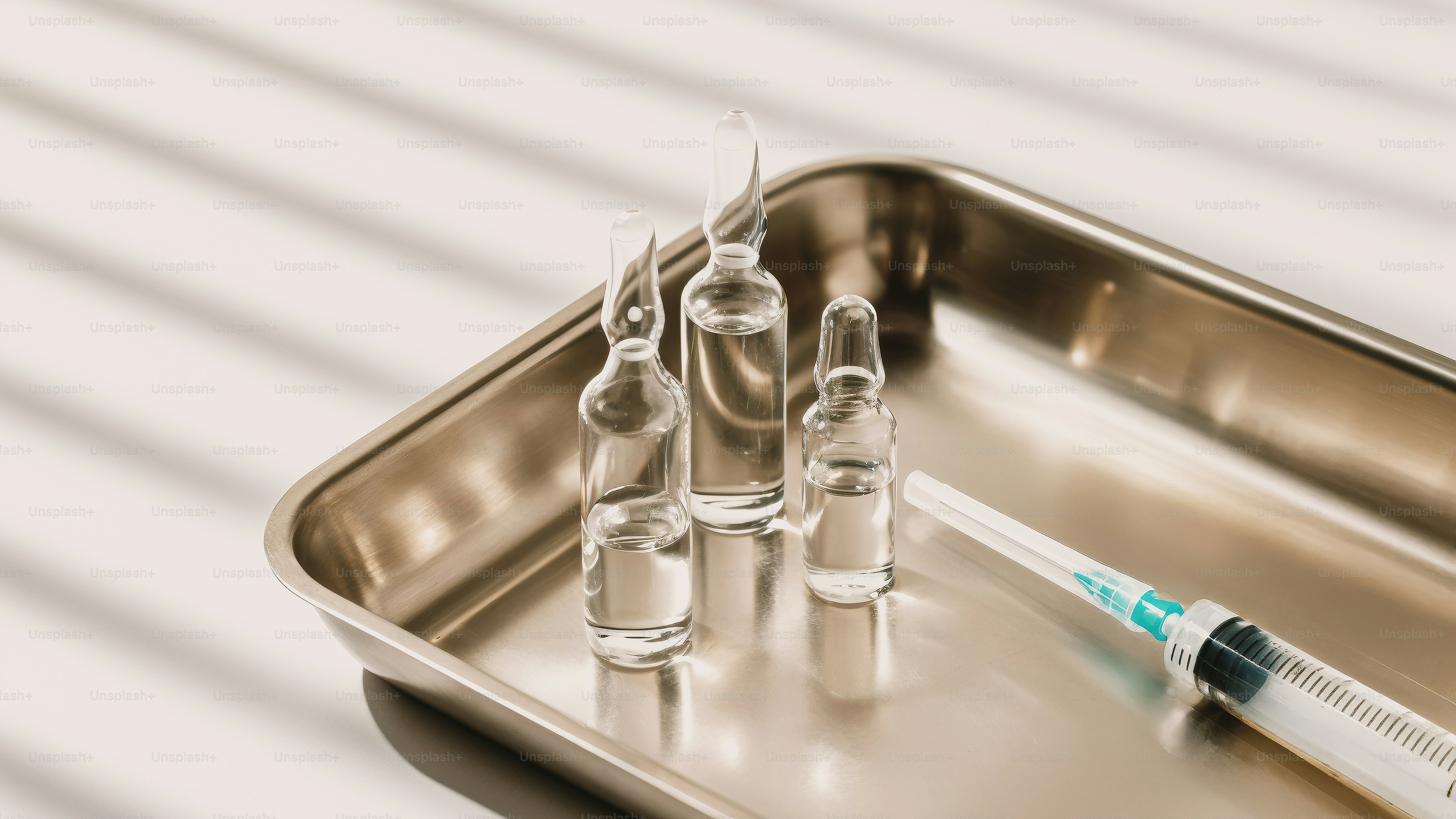 Syringes and vials are on a tray. photo – Medical Image on Unsplash