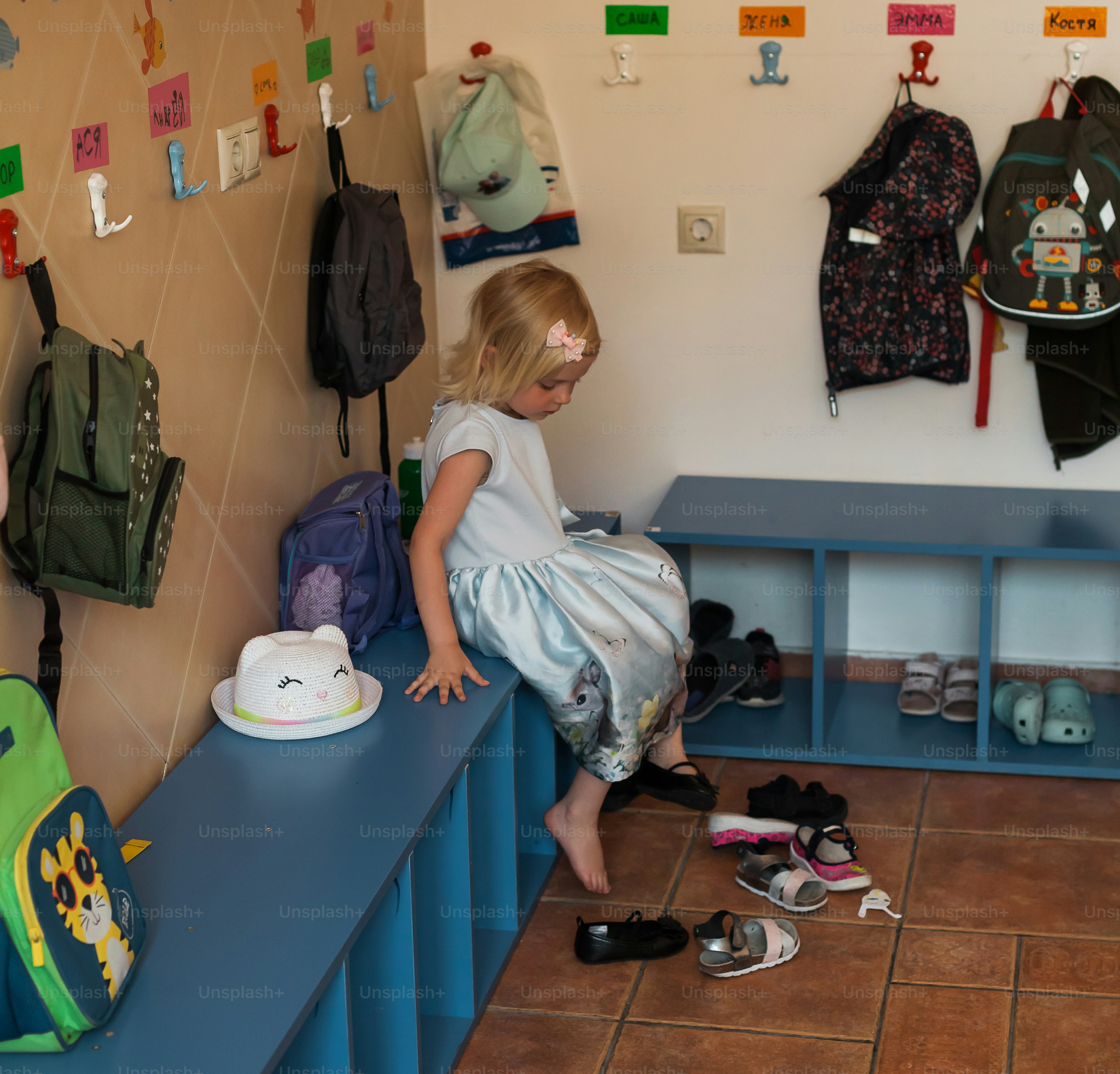 Ein kleines Mädchen zieht ihre Schuhe aus.