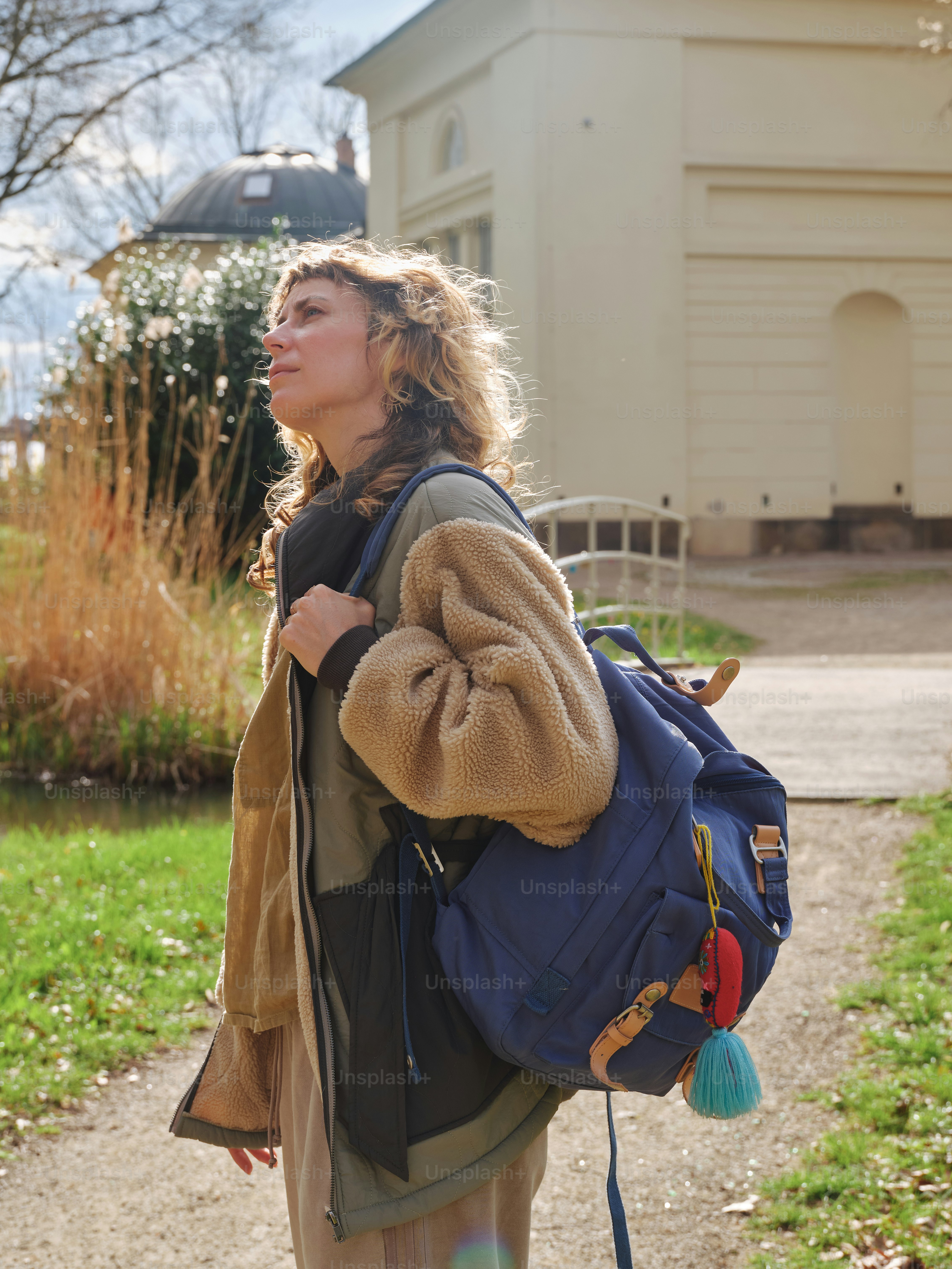 Woman gazes upward, carrying a backpack