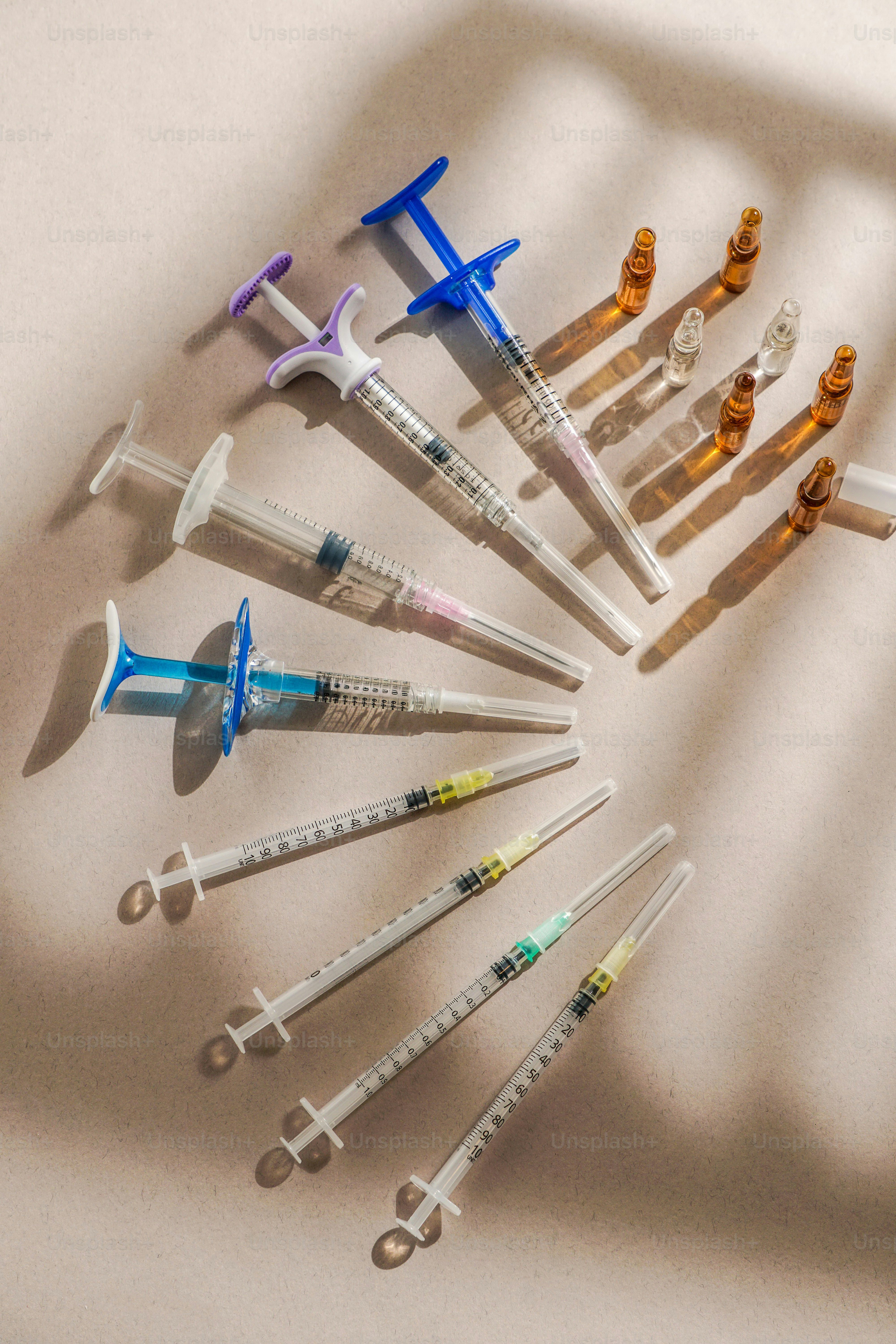 Syringes and vials lay on a light-colored surface.