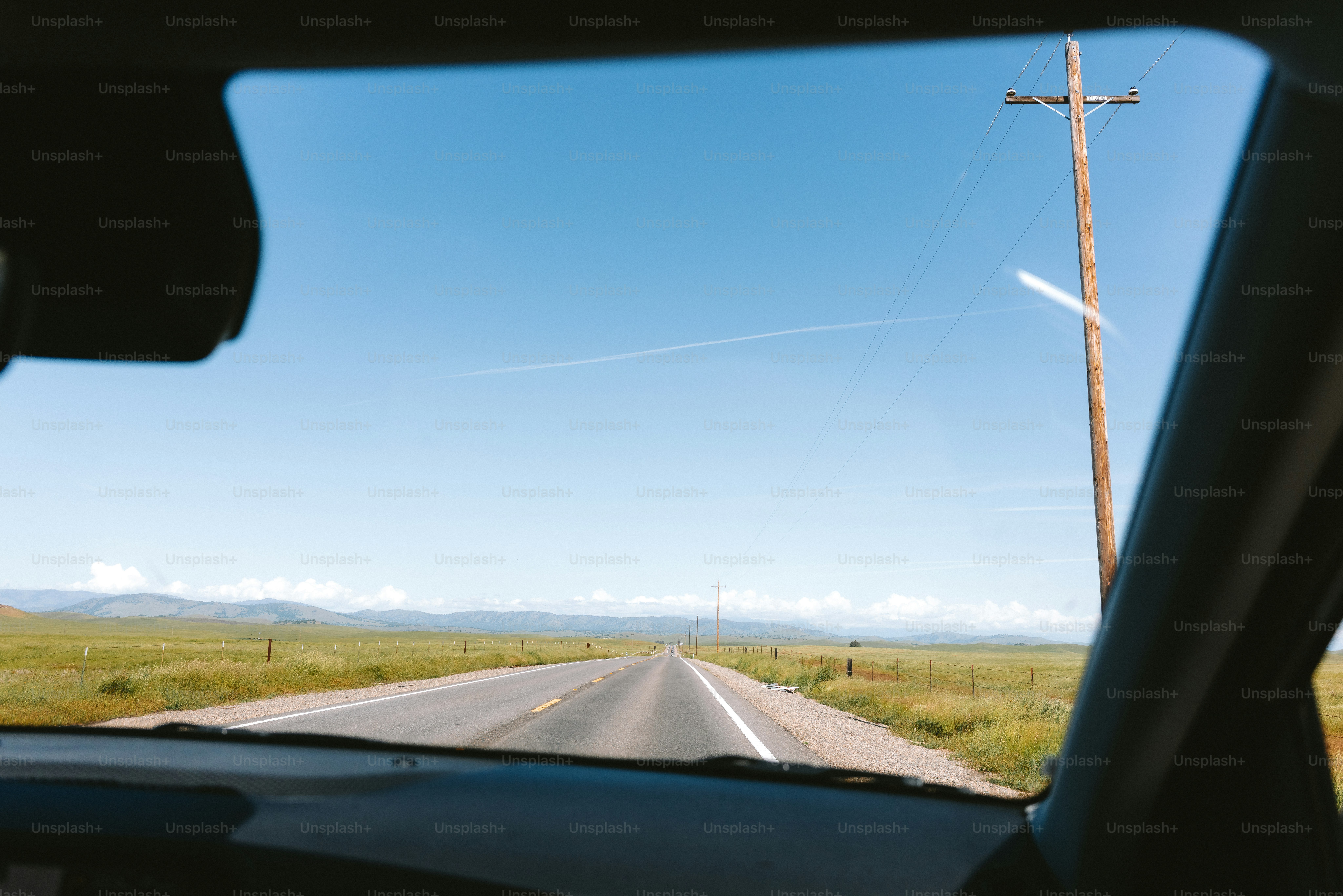 Driving on a road, seen through a windshield.