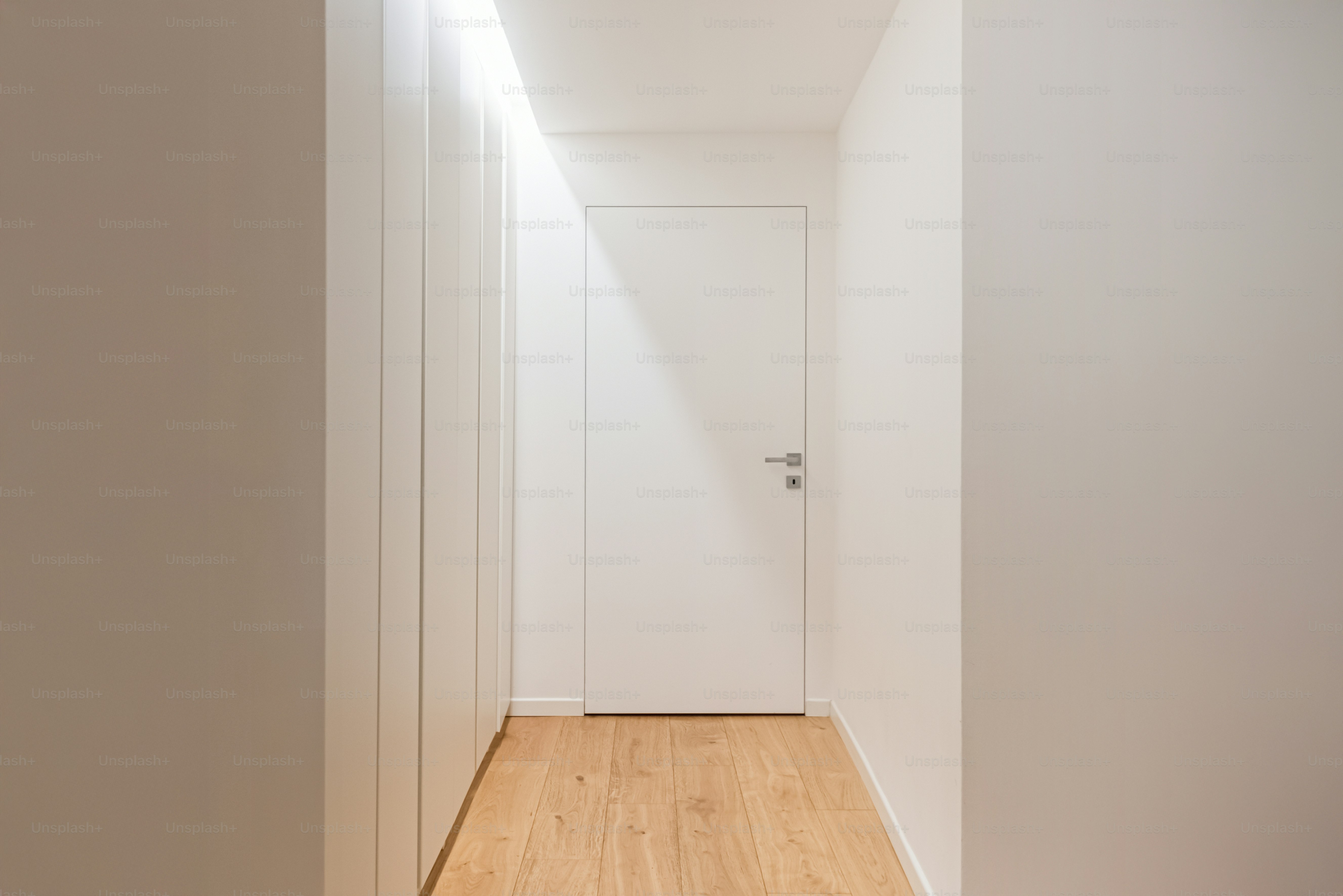 A bright, narrow hallway with white walls.