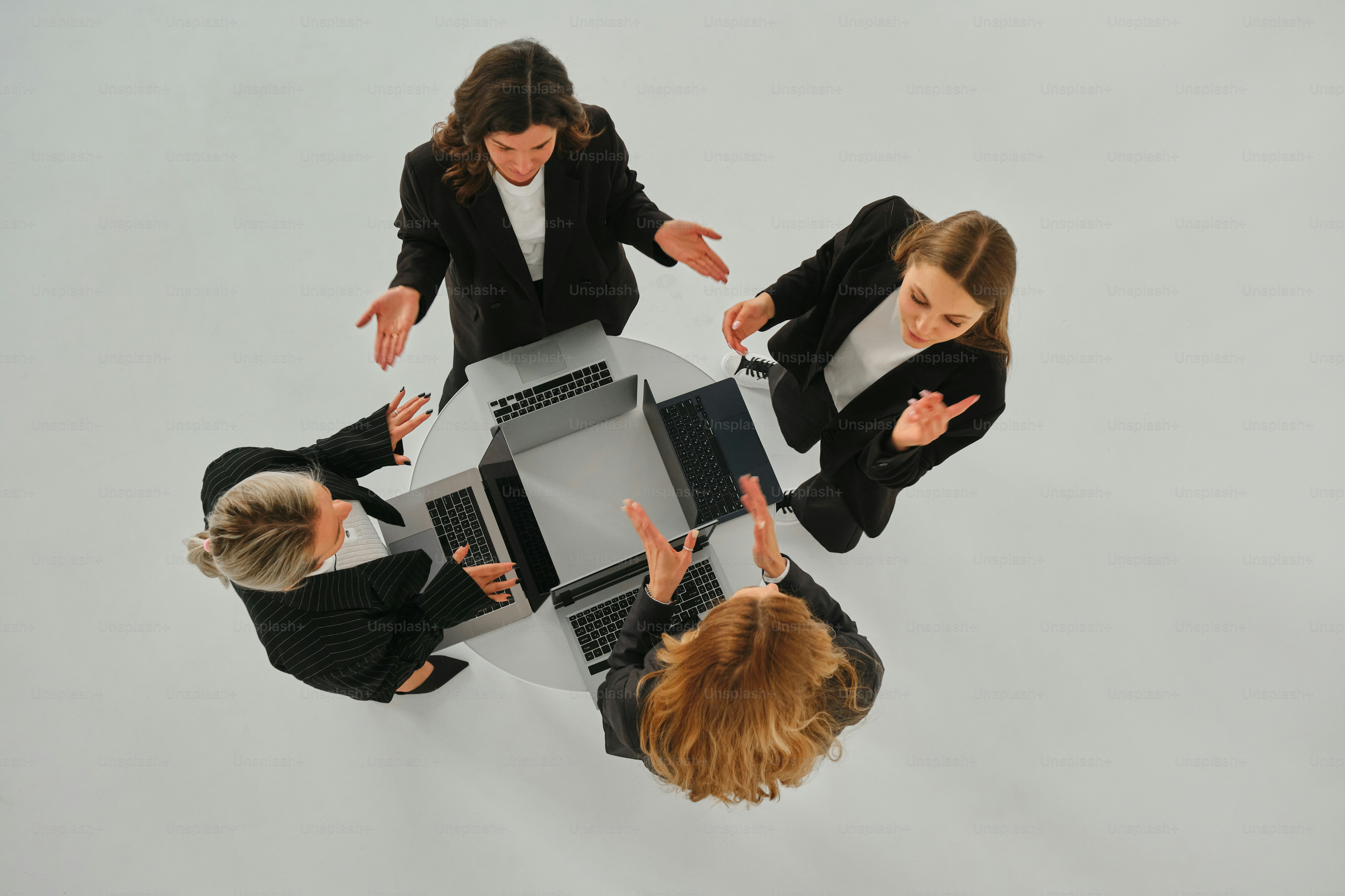 Las empresarias se reúnen alrededor de una mesa.