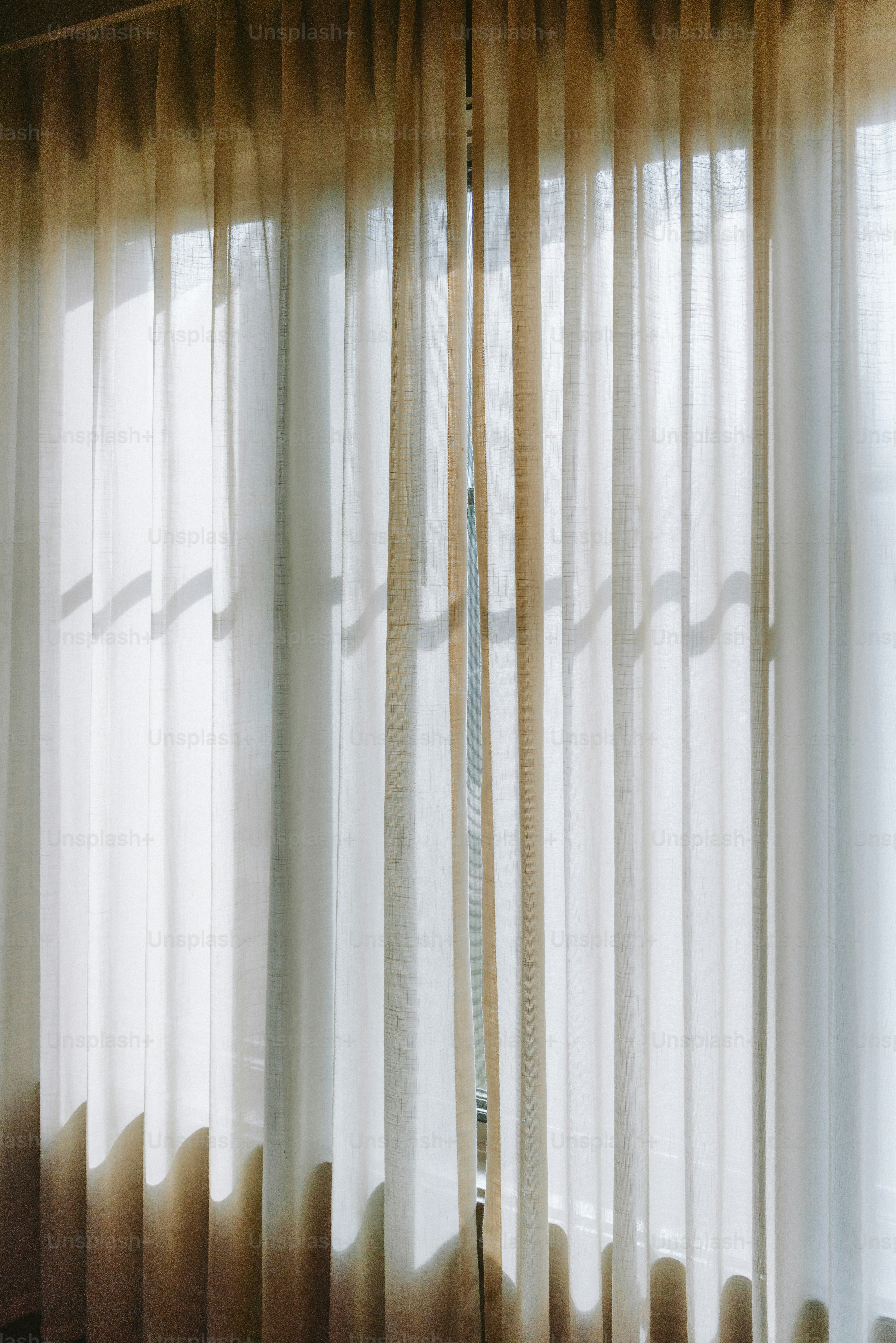 Sheer white curtains allow sunlight to softly filter
