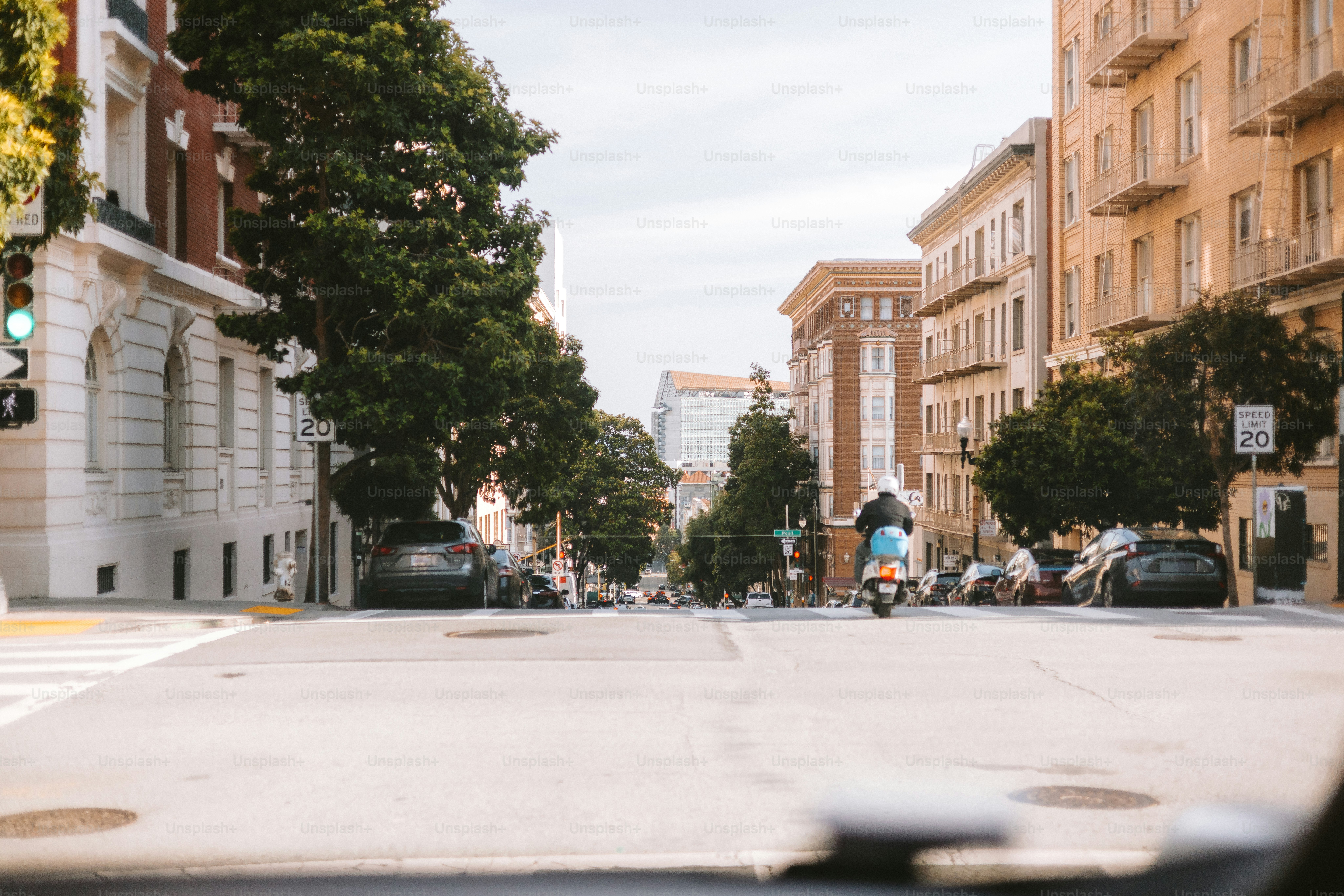 A scooter drives down a city street.