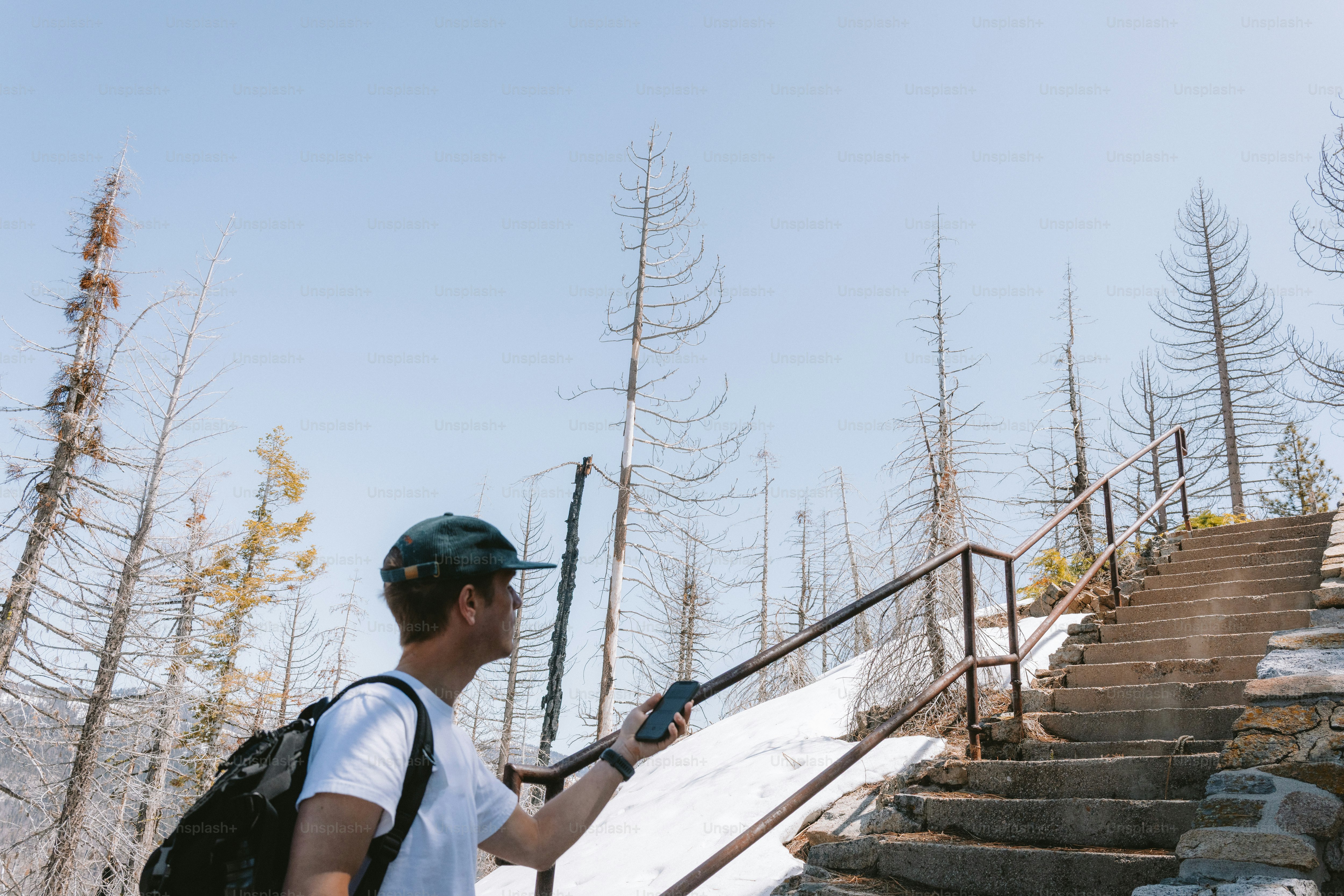 Hiker using hiking GPS devices on a remote mountain trail during changing weather conditions